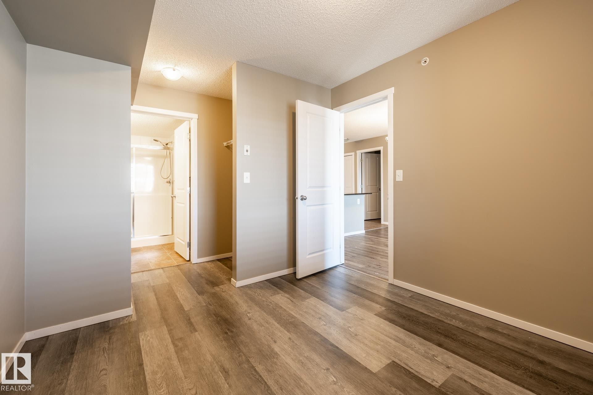 Spare room featuring a textured ceiling and wood finished floors - 433 3315 James Mowatt Trail, Edmonton, AB - Indoor Photo Showing Other Room