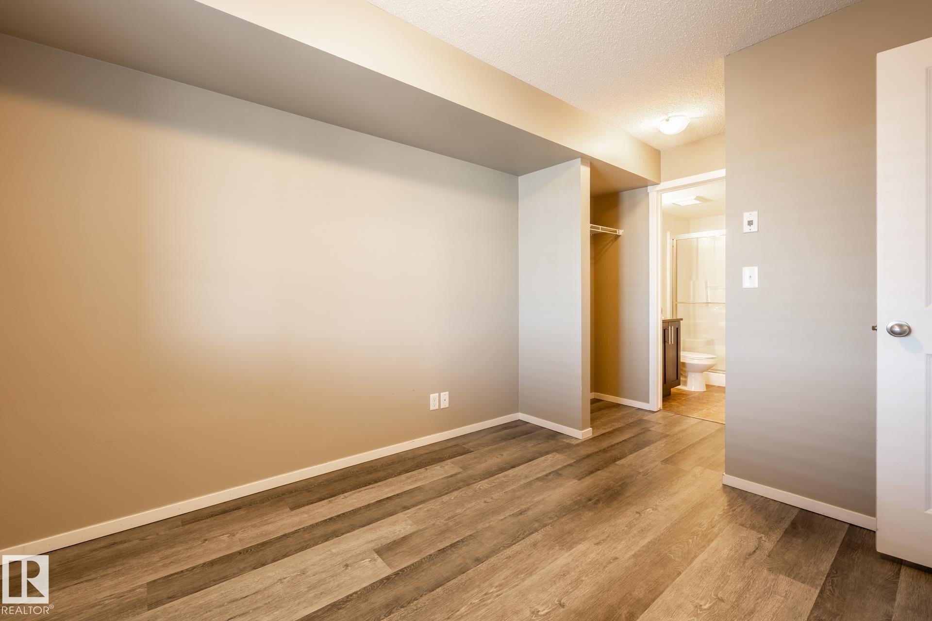 Empty room featuring a textured ceiling and light wood-type flooring - 433 3315 James Mowatt Trail, Edmonton, AB - Indoor Photo Showing Other Room