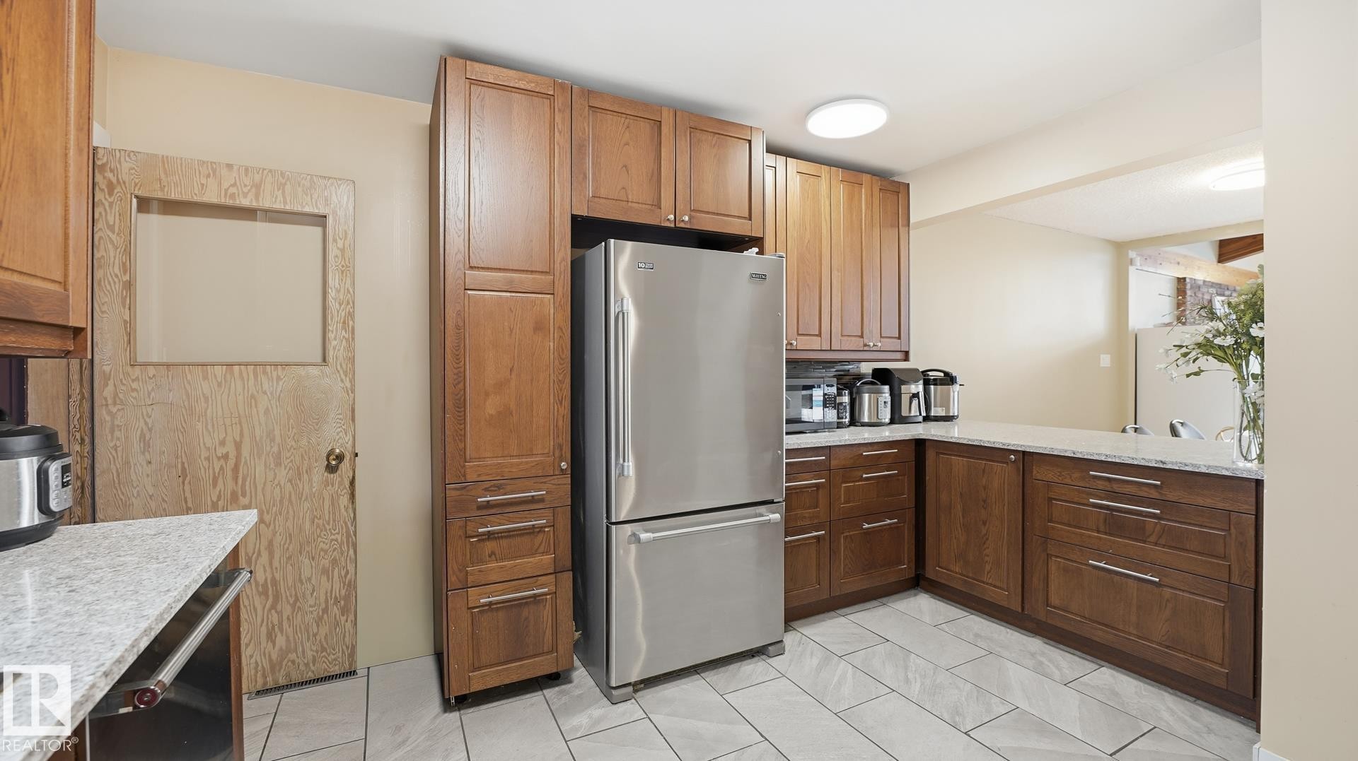 Kitchen featuring stainless steel appliances and light stone countertops - 11520 78 Avenue Nw, Edmonton, AB - Indoor Photo Showing Kitchen