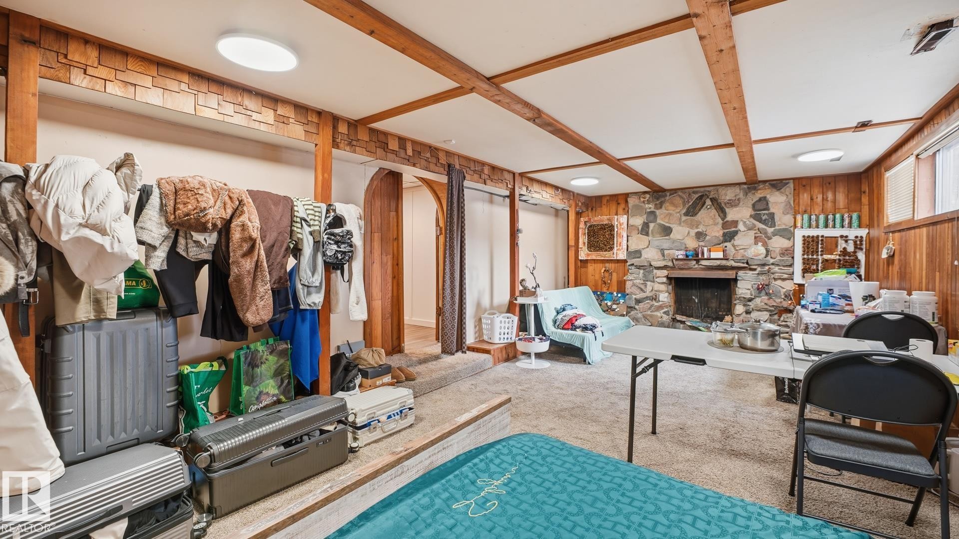 Living room with wooden walls, a stone fireplace, carpet floors, and coffered ceiling - 11520 78 Avenue Nw, Edmonton, AB - Indoor With Fireplace