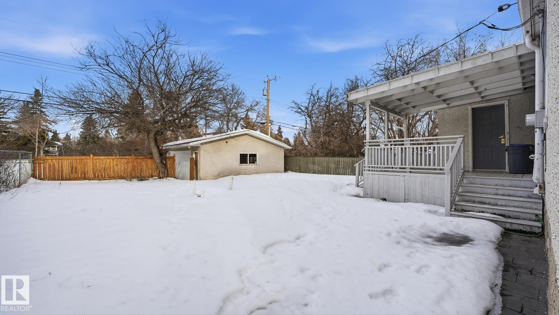 Yard covered in snow with a fenced backyard, an outdoor structure, and a wooden deck - 11520 78 Avenue Nw, Edmonton, AB - Outdoor