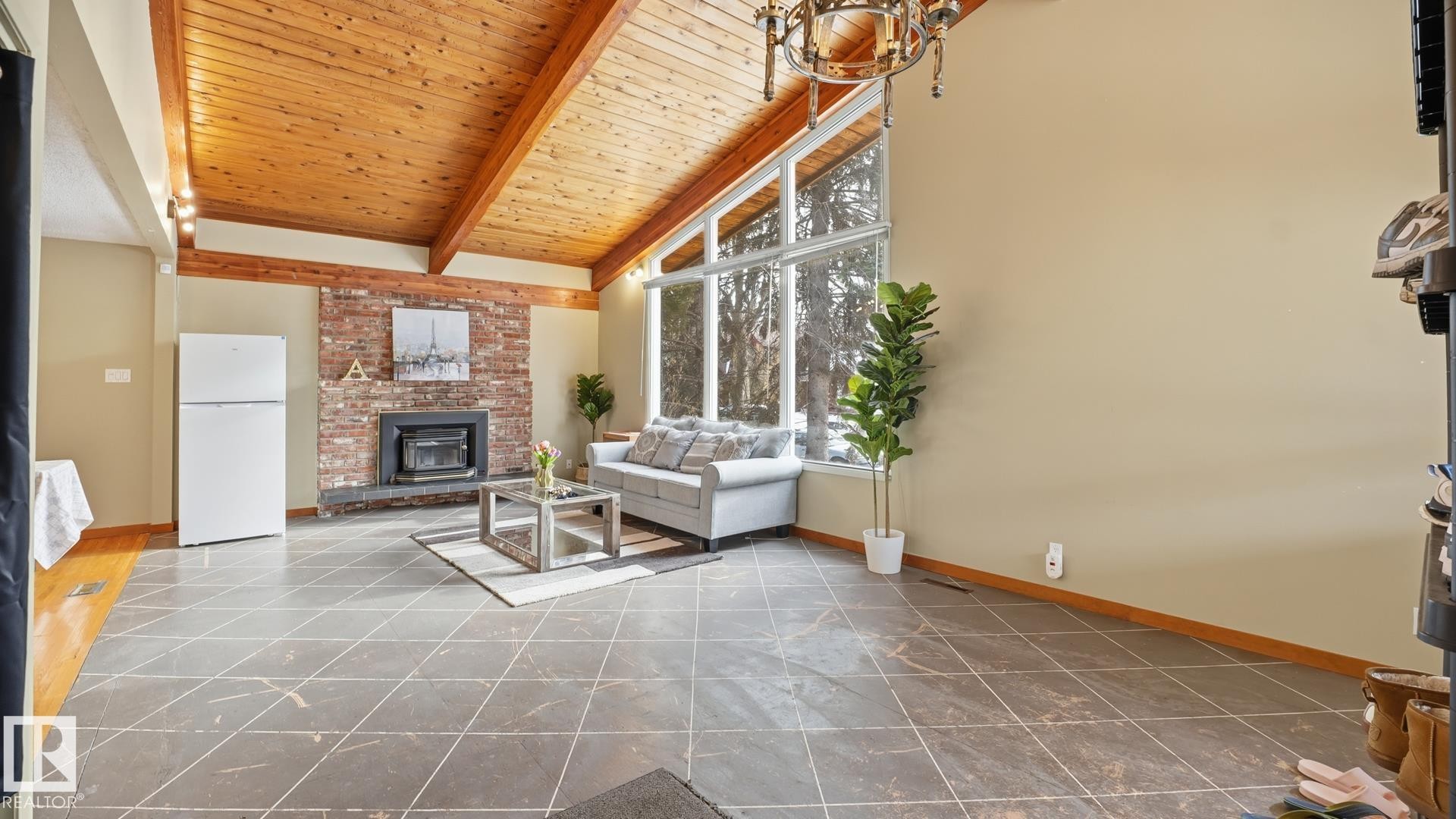 Living room with a high wooden beamed ceiling and a brick fireplace - 11520 78 Avenue Nw, Edmonton, AB - Indoor With Fireplace
