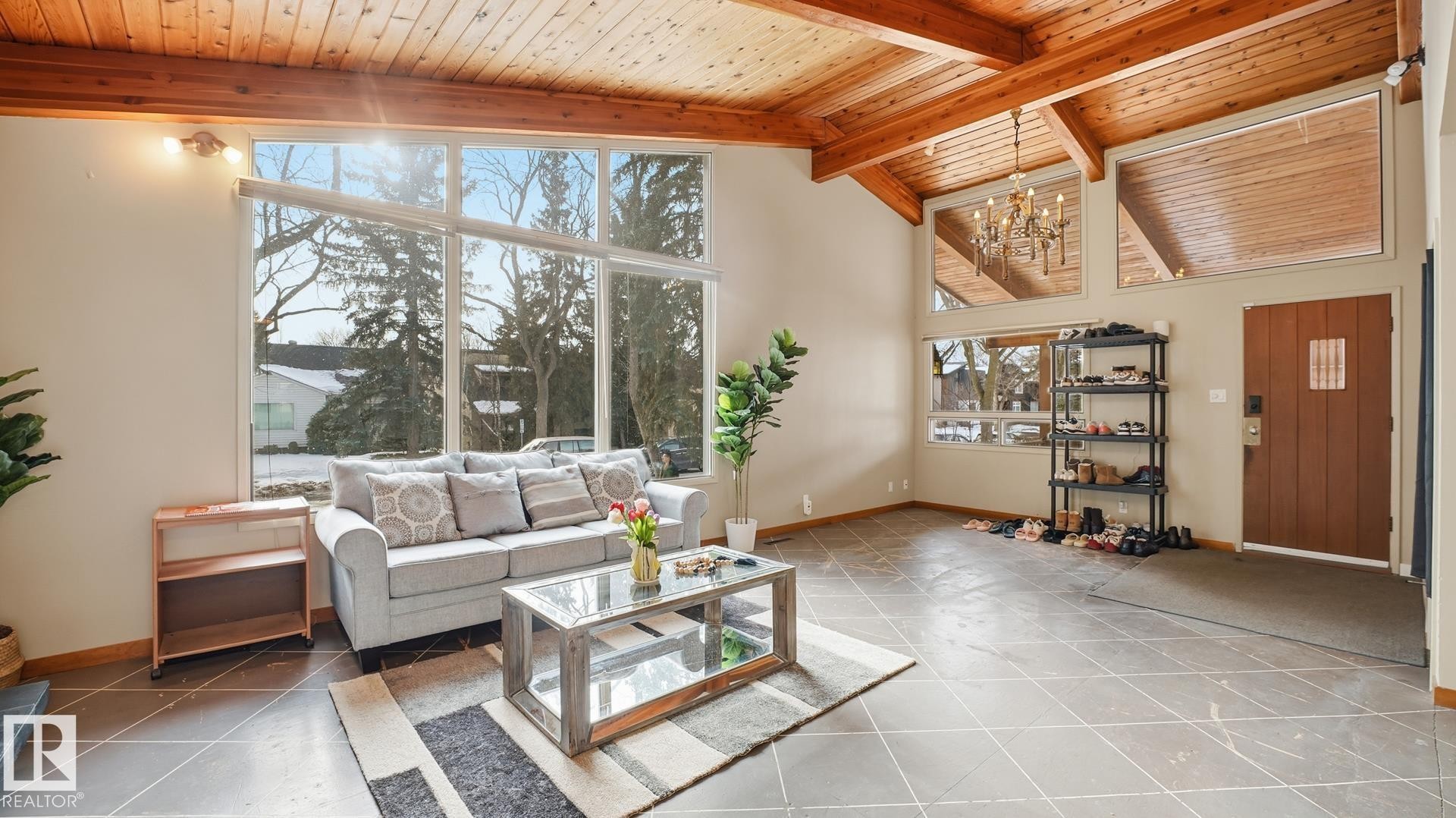 Living room with a high wood beamed ceiling, hanging lights, and tile patterned flooring - 11520 78 Avenue Nw, Edmonton, AB - Indoor Photo Showing Other Room