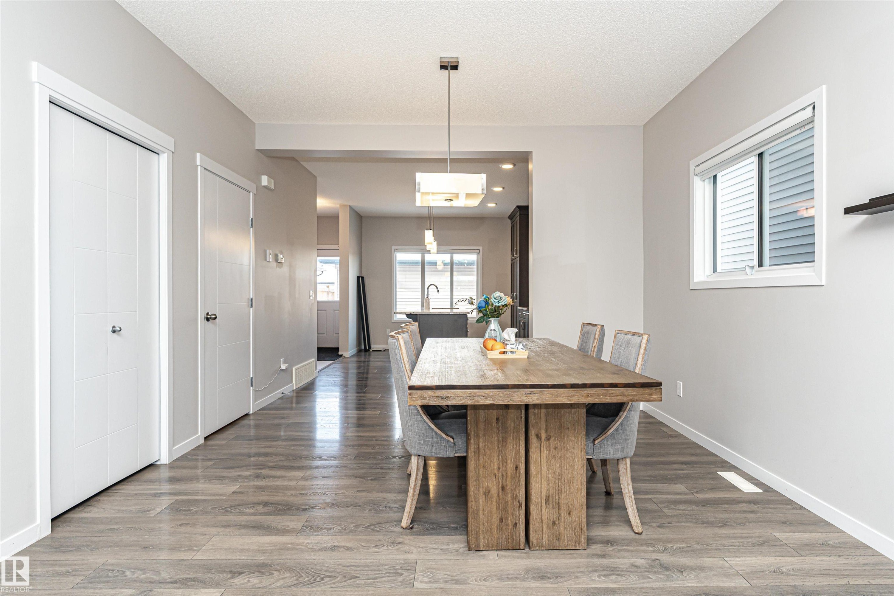 Dining area with light wood finished floors and a textured ceiling - 4008 Allan Crescent, Edmonton, AB - Indoor Photo Showing Dining Room