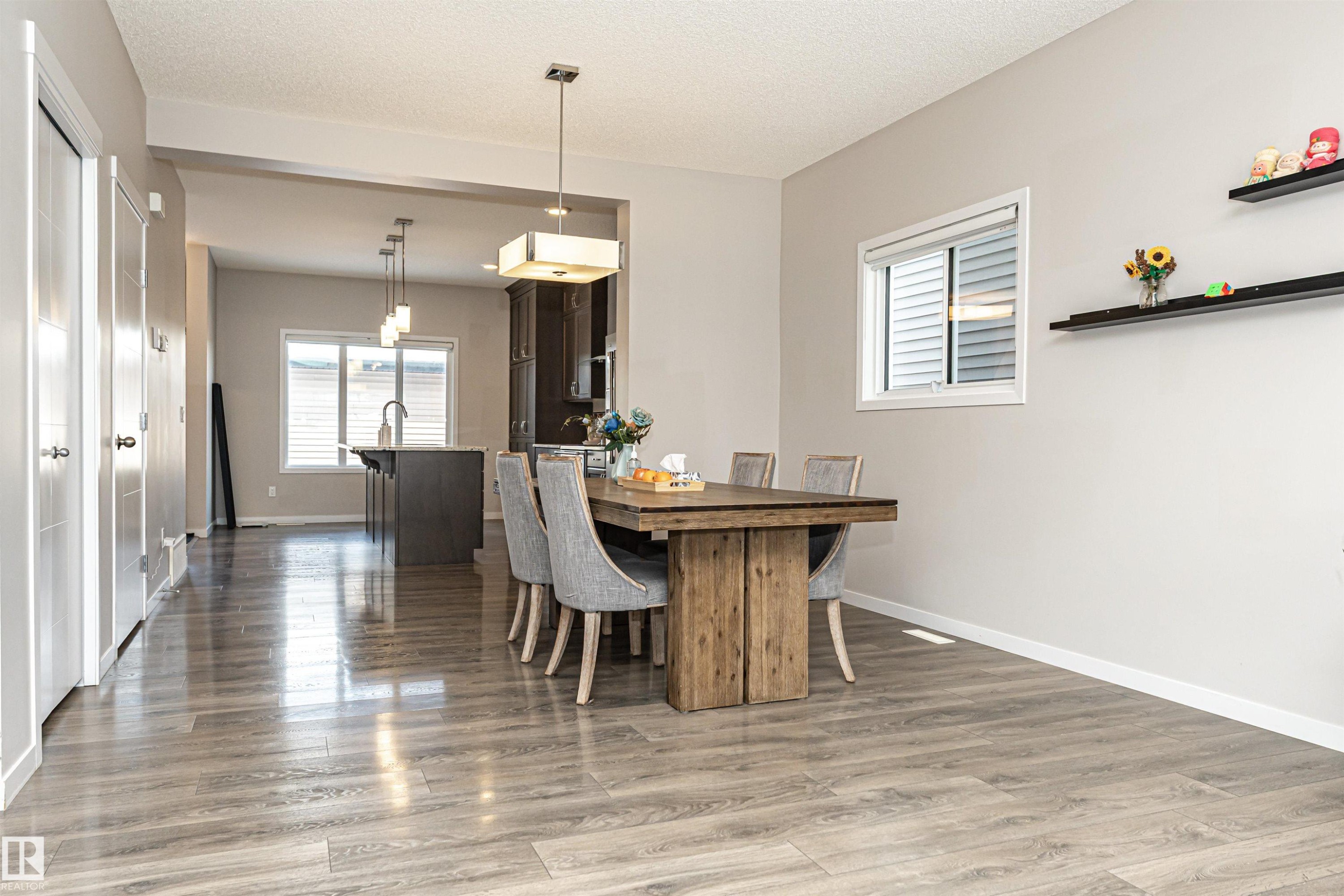 Dining room featuring light wood-style floors and a textured ceiling - 4008 Allan Crescent, Edmonton, AB - Indoor Photo Showing Dining Room