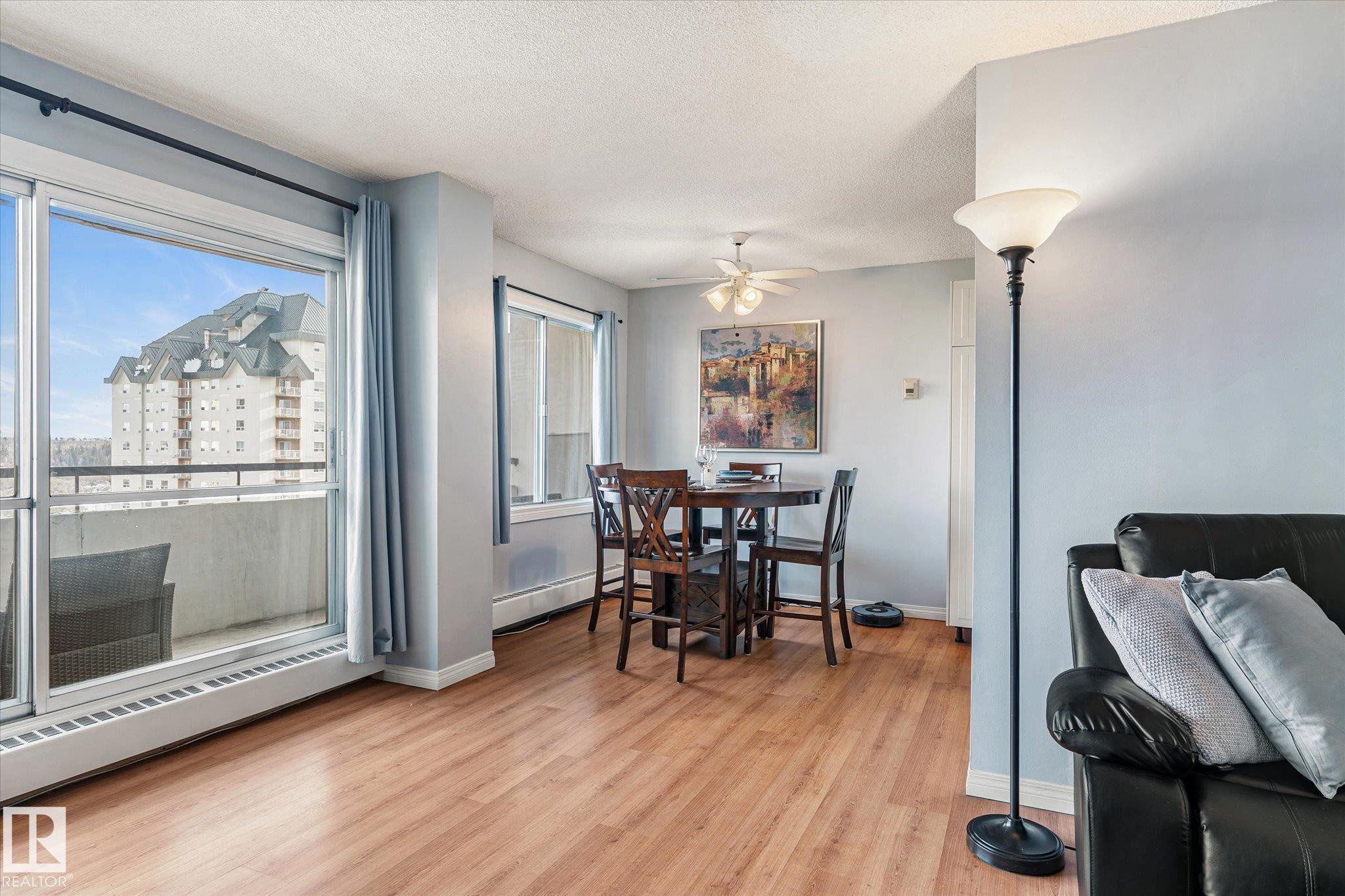 Dining area with light wood-type flooring, baseboard heating, a textured ceiling, and a ceiling fan - 304 9725 106 Street, Edmonton, AB - Indoor