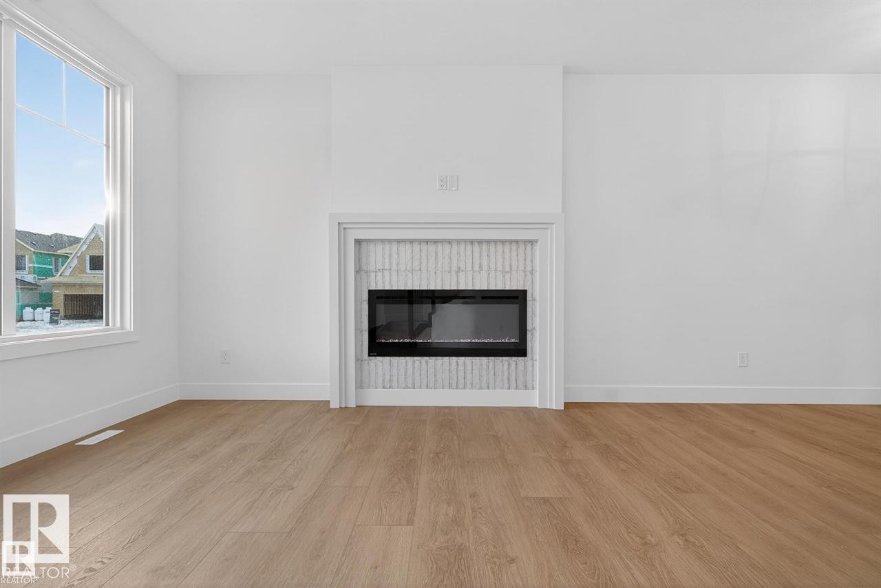 Detailed view of wood finished floors and a glass covered fireplace - 47 River Birch Way, St. Albert, AB - Indoor Photo Showing Living Room