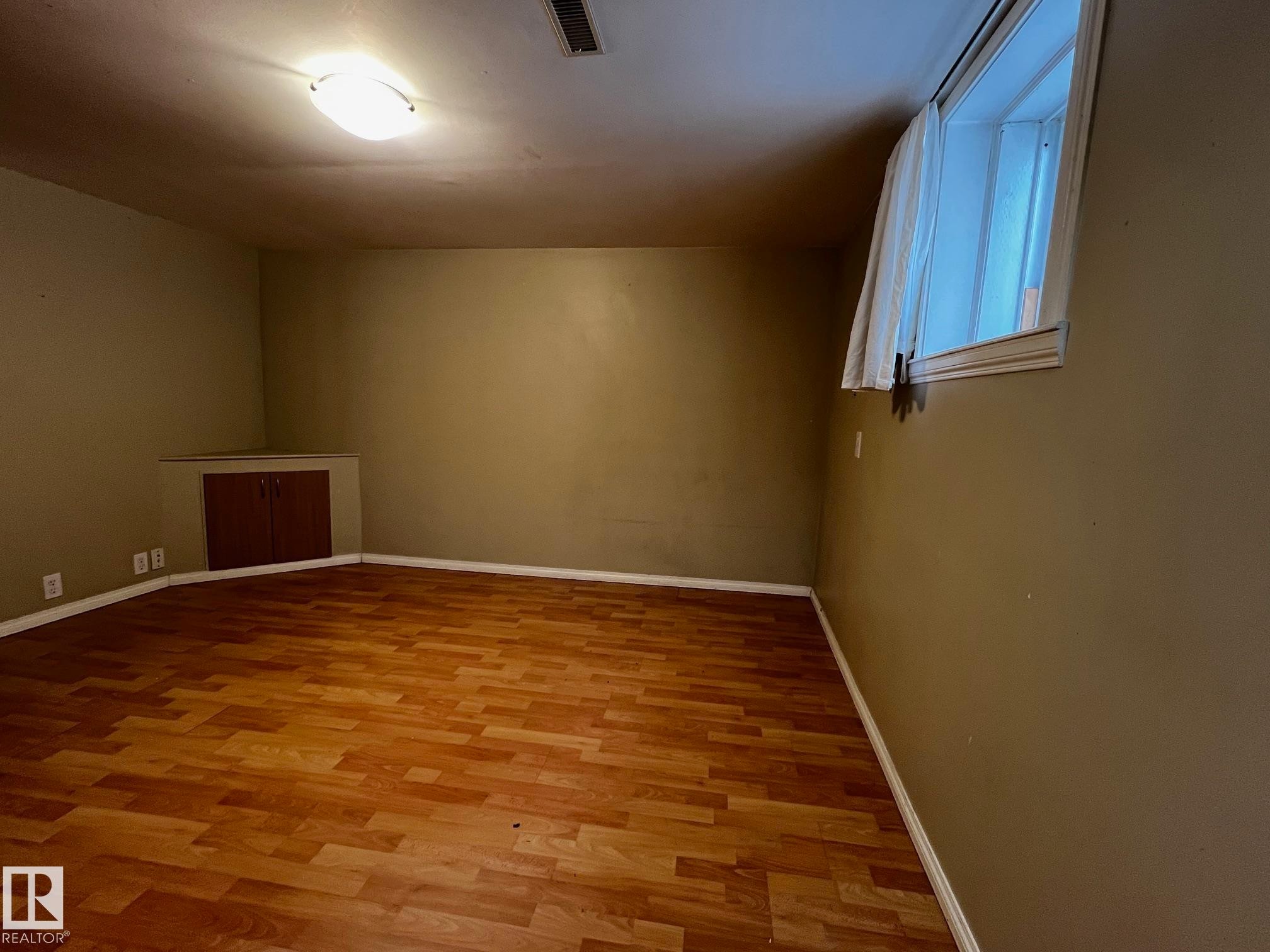 Empty room featuring wood finished floors and baseboards - 10830 68 Avenue, Edmonton, AB - Indoor Photo Showing Other Room