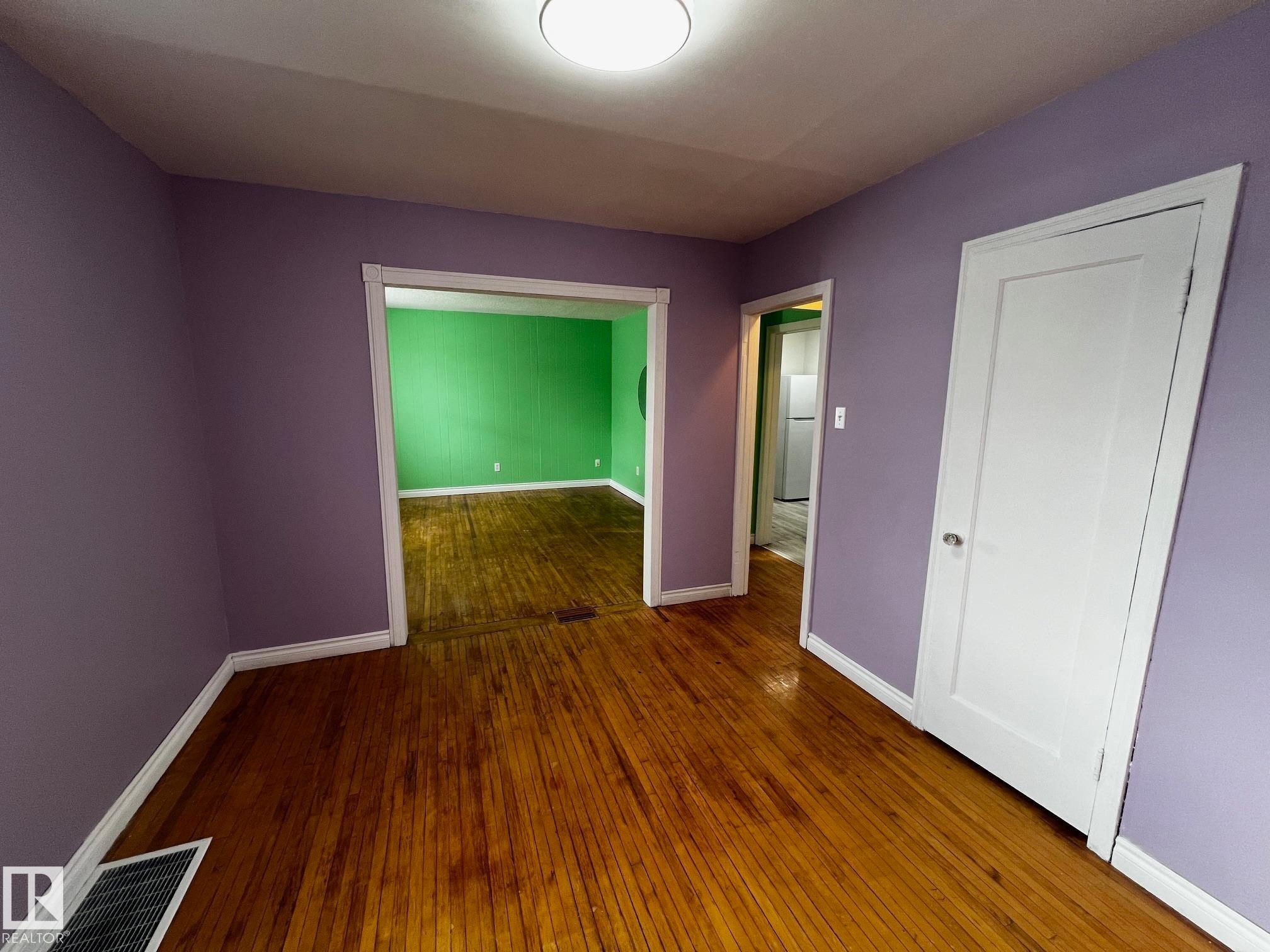 Spare room featuring baseboards and dark wood-type flooring - 10830 68 Avenue, Edmonton, AB - Indoor