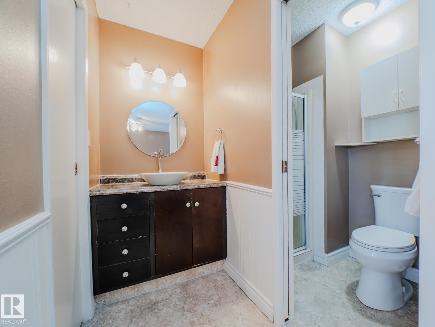 Bathroom featuring a wainscoted wall, vanity, a stall shower, and a decorative wall - 3204 113B Street, Edmonton, AB - Indoor Photo Showing Bathroom