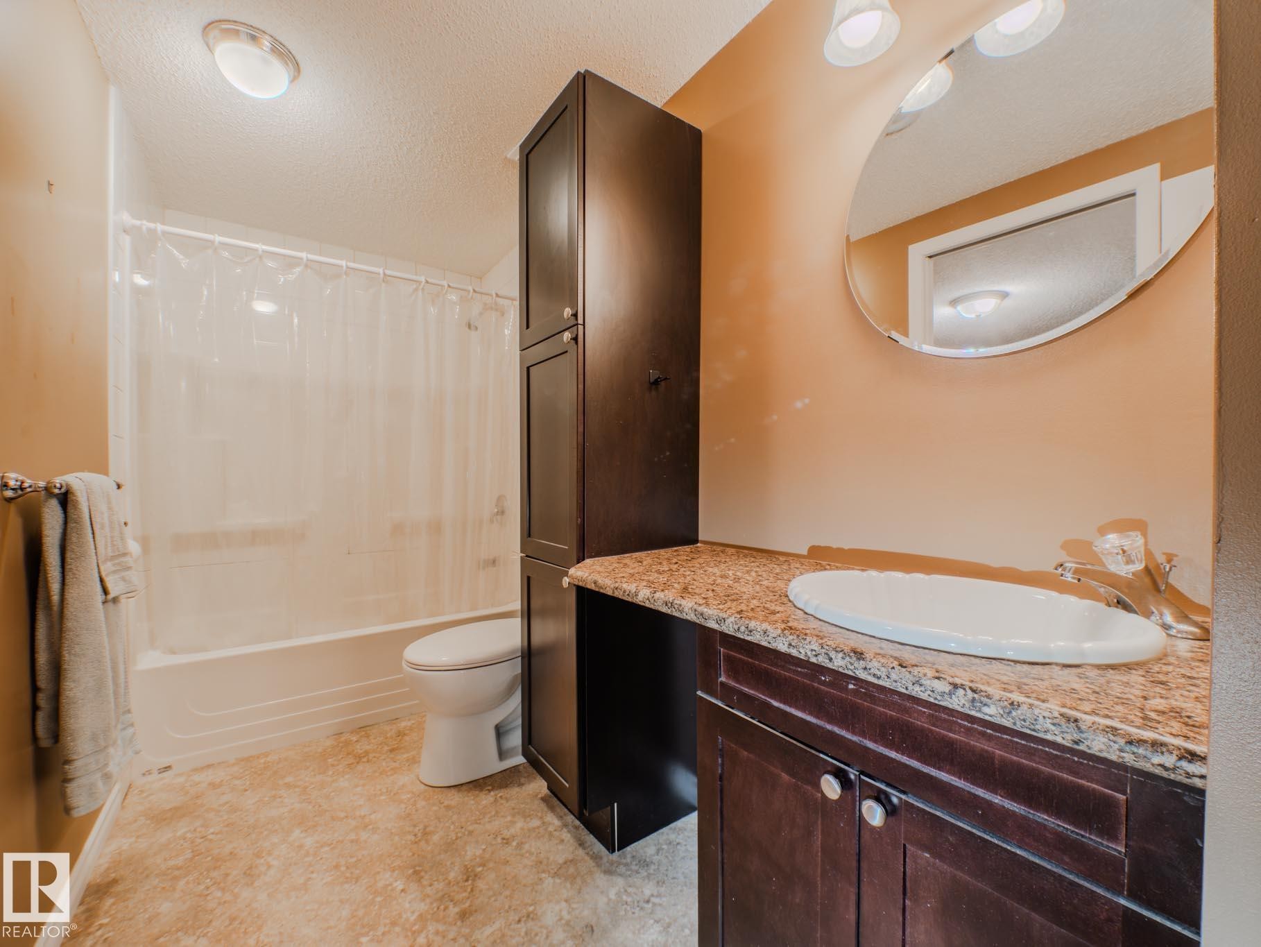 Bathroom featuring a textured ceiling, vanity, and shower / bath combination with curtain - 3204 113B Street, Edmonton, AB - Indoor Photo Showing Bathroom