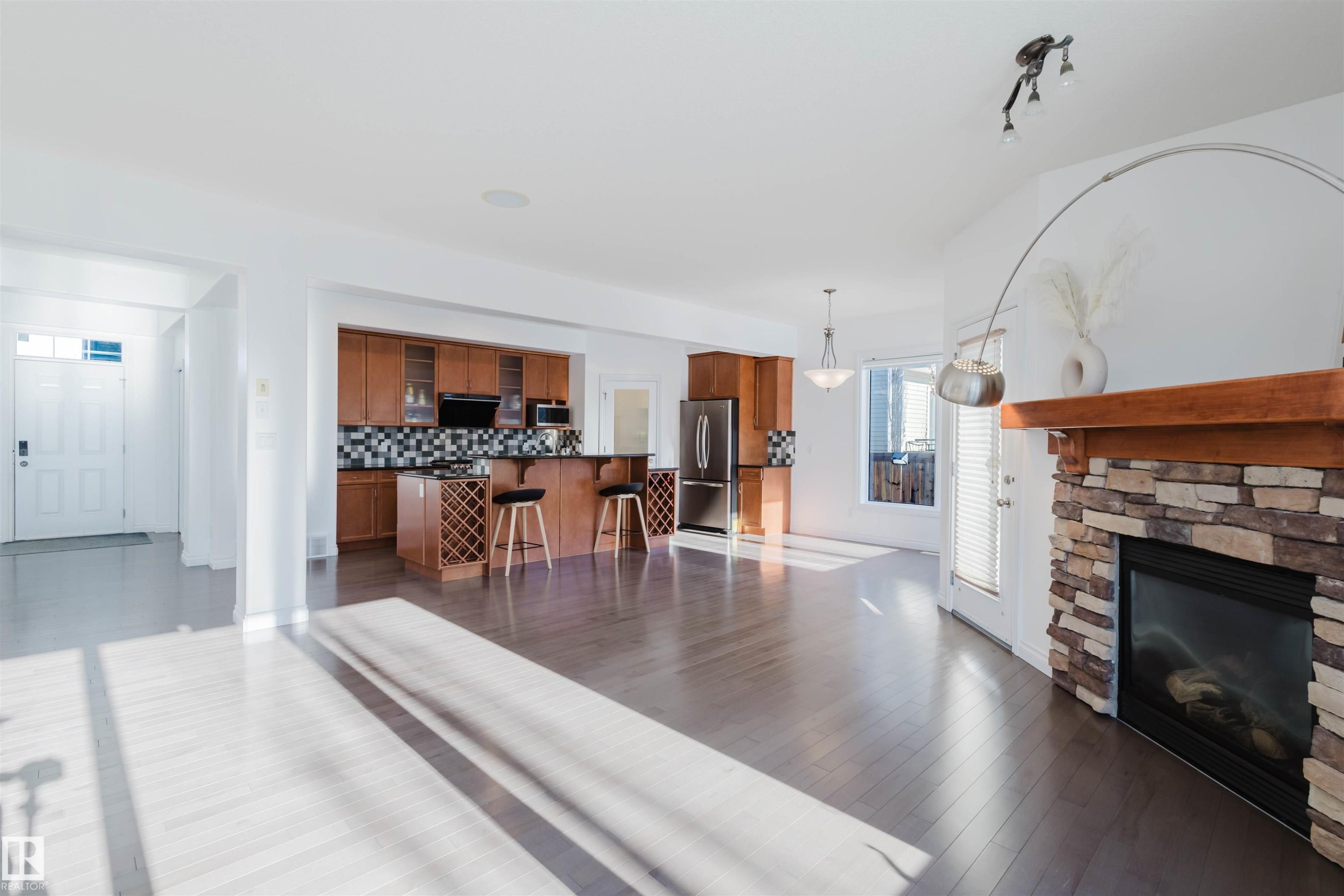 Living room featuring a fireplace and dark wood finished floors - 3547 Mclay Crescent, Edmonton, AB - Indoor Photo Showing Living Room With Fireplace