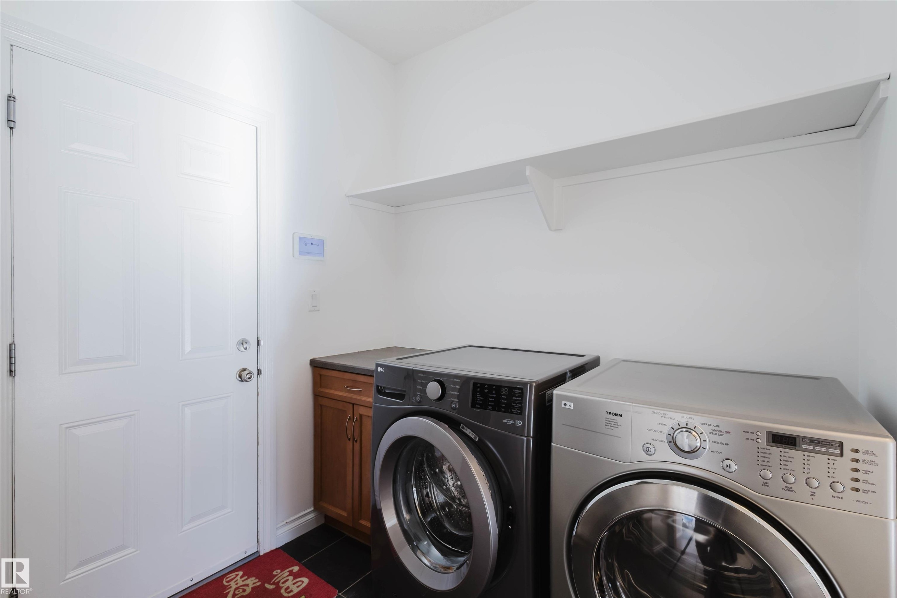 Laundry room featuring washer and dryer and dark tile patterned floors - 3547 Mclay Crescent, Edmonton, AB - Indoor Photo Showing Laundry Room