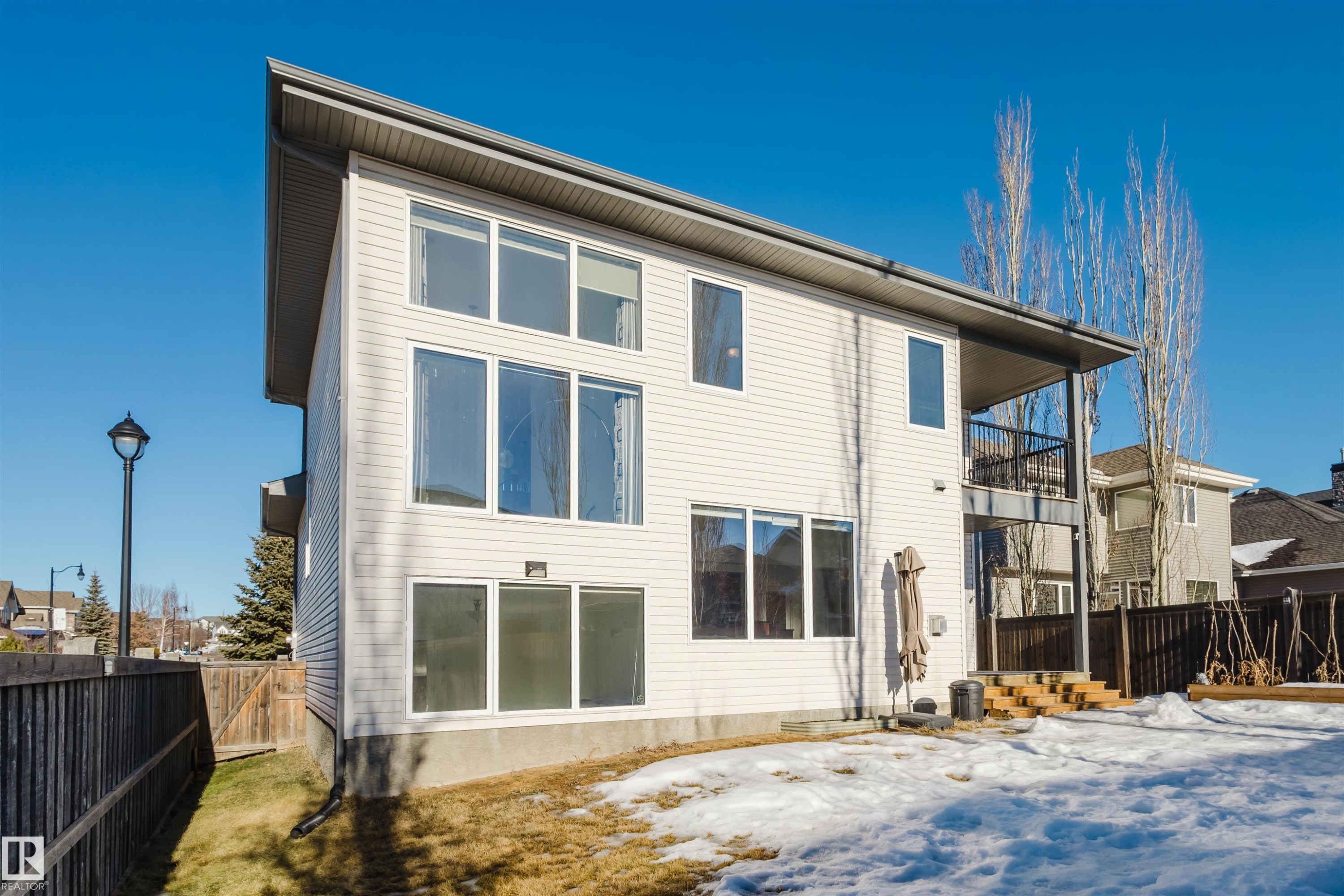 Snow covered rear of property with a fenced backyard, a balcony, and a gate - 3547 Mclay Crescent, Edmonton, AB - Outdoor