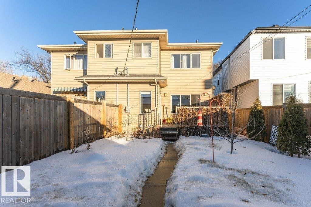 Snow covered house with a fenced backyard and a wooden deck - 10535 67 Avenue, Edmonton, AB - Outdoor With Deck Patio Veranda