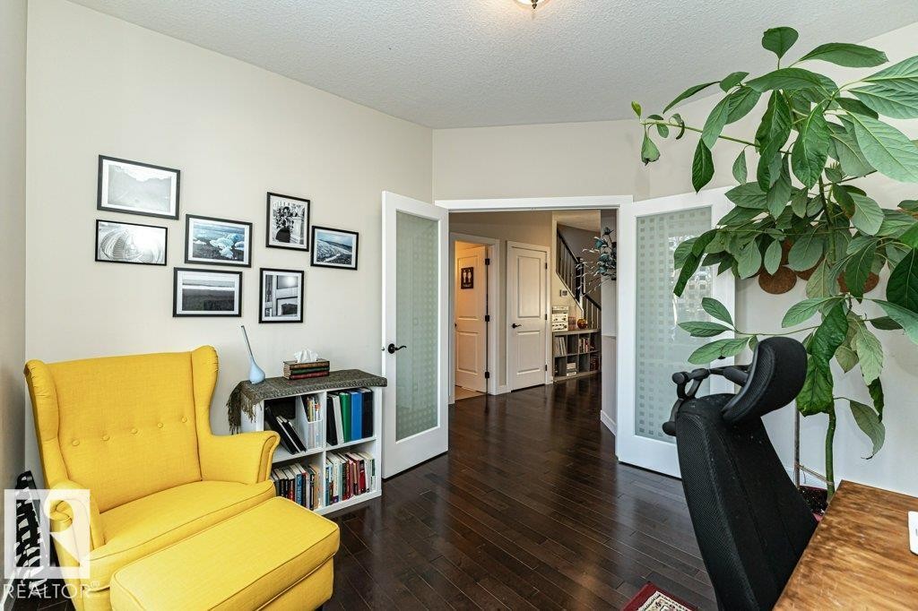 Sitting room with french doors, dark wood finished floors, and a textured ceiling - 10535 67 Avenue, Edmonton, AB - Indoor