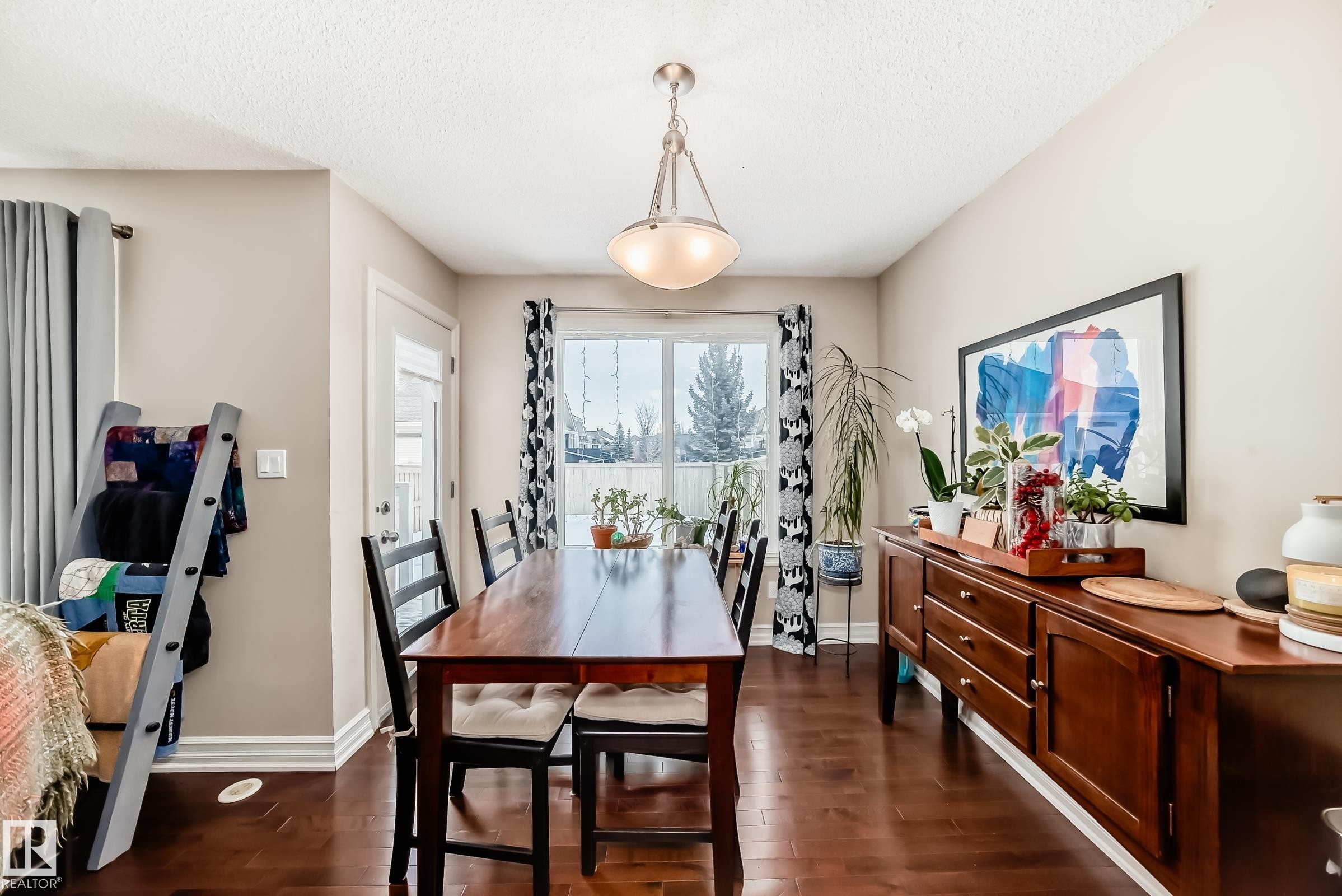 Dining area with dark wood finished floors and a textured ceiling - 9645 Simpson Place, Edmonton, AB
