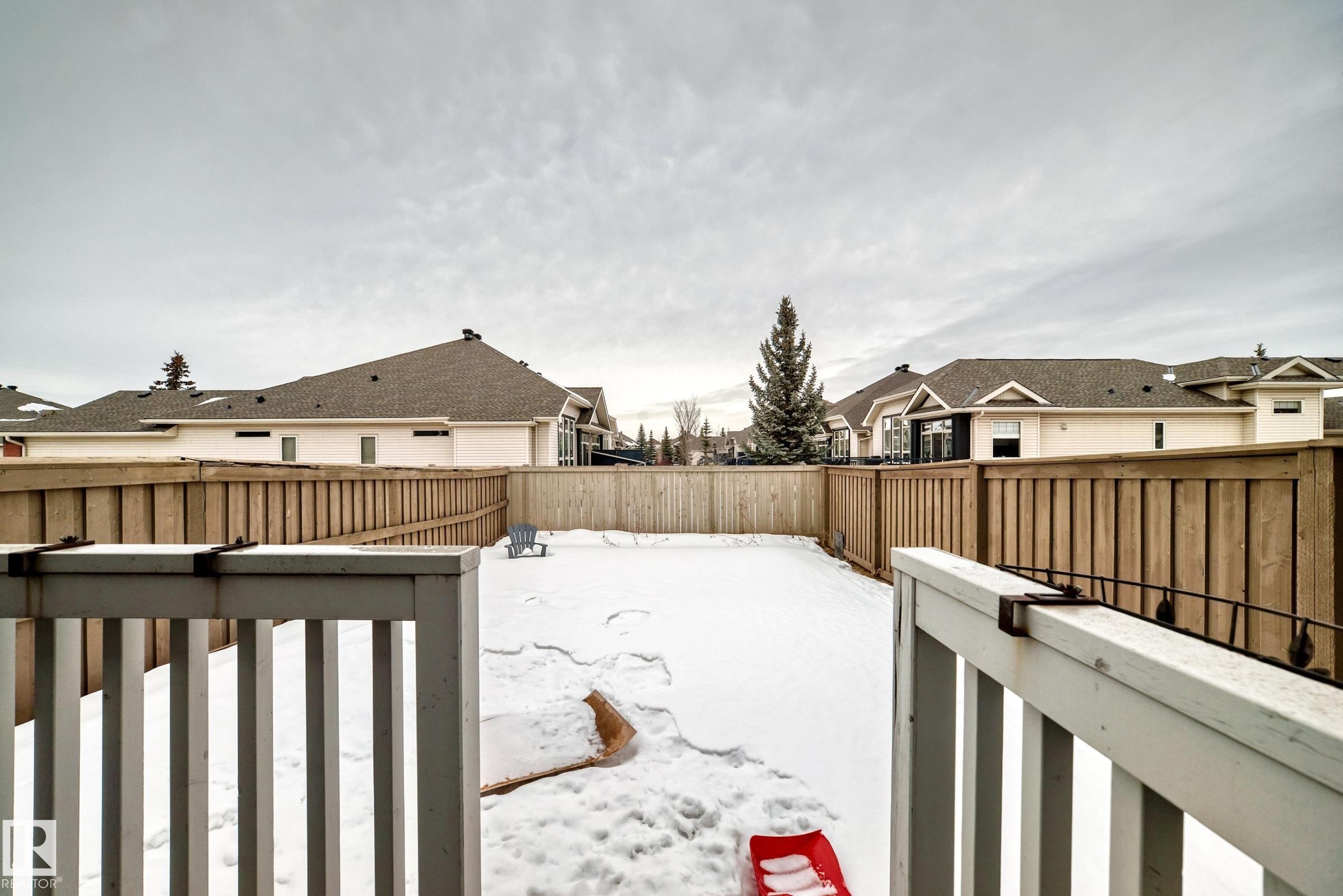 Fenced backyard featuring a residential view and a wooden deck - 9645 Simpson Place, Edmonton, AB