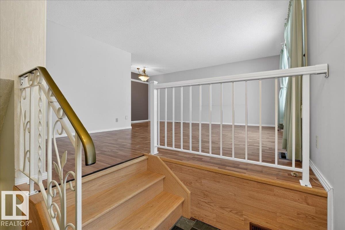 Stairs with wood finished floors and a textured ceiling - Edmonton, AB - Indoor Photo Showing Other Room