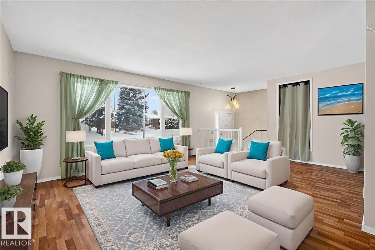 Living room featuring wood finished floors and suspended lighting - Edmonton, AB - Indoor Photo Showing Living Room