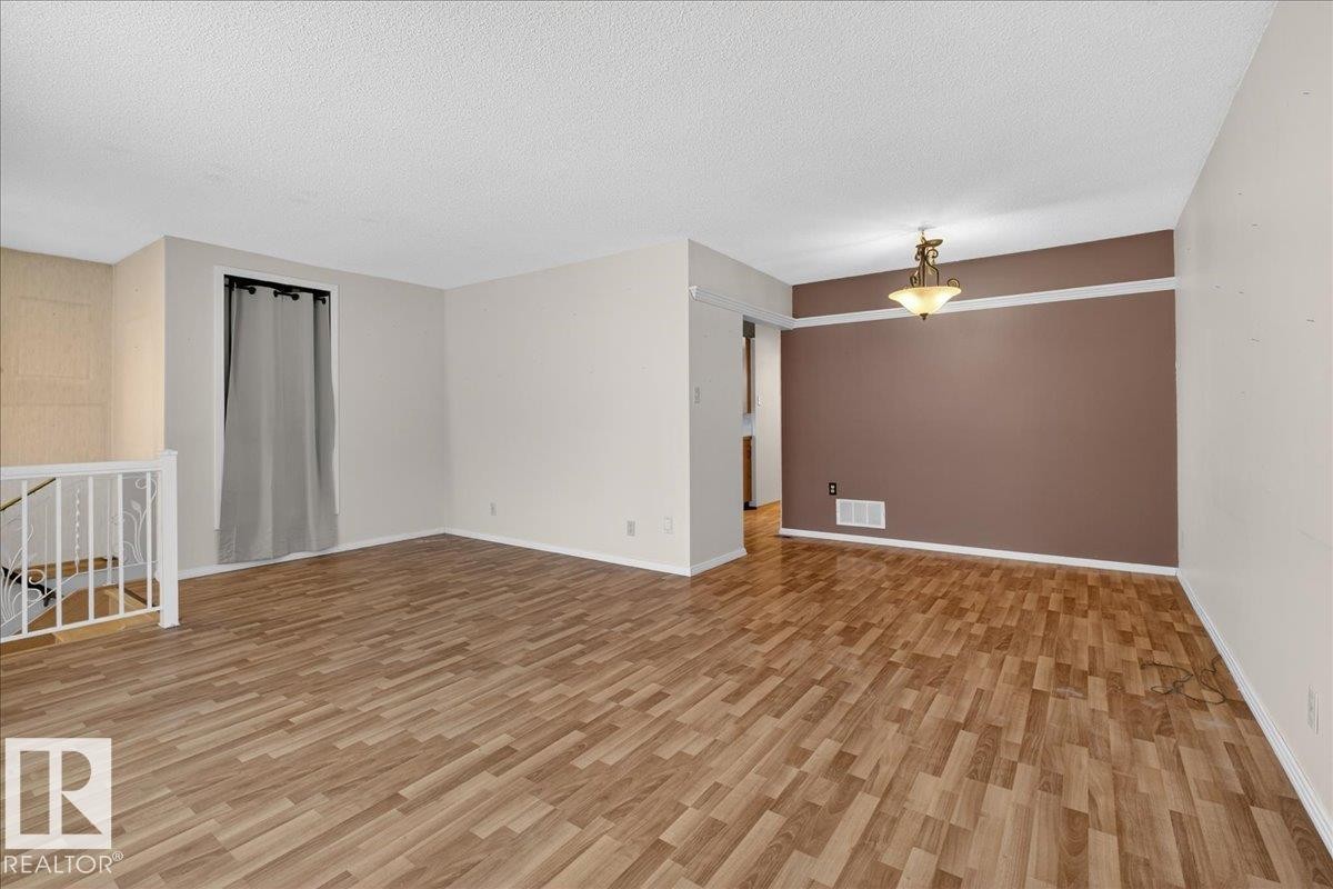 Empty room featuring light wood finished floors and a textured ceiling - Edmonton, AB - Indoor Photo Showing Other Room