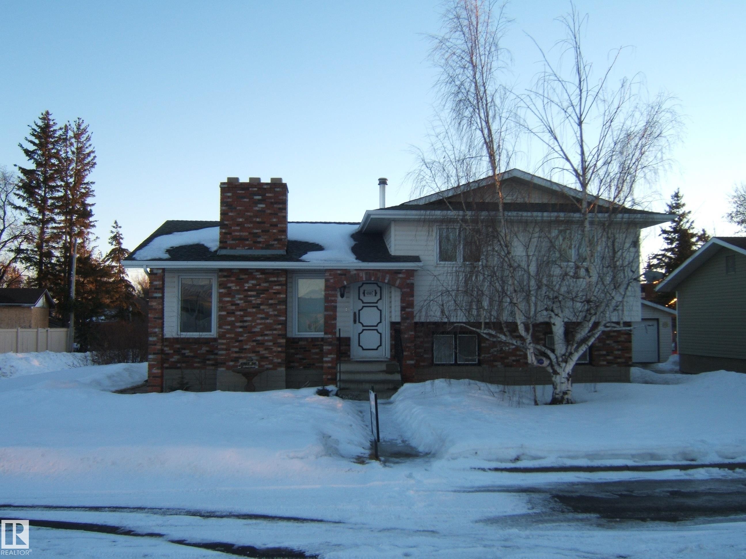 Split level home with a chimney and brick siding - 4807 54 Avenue, Two Hills, AB - Outdoor
