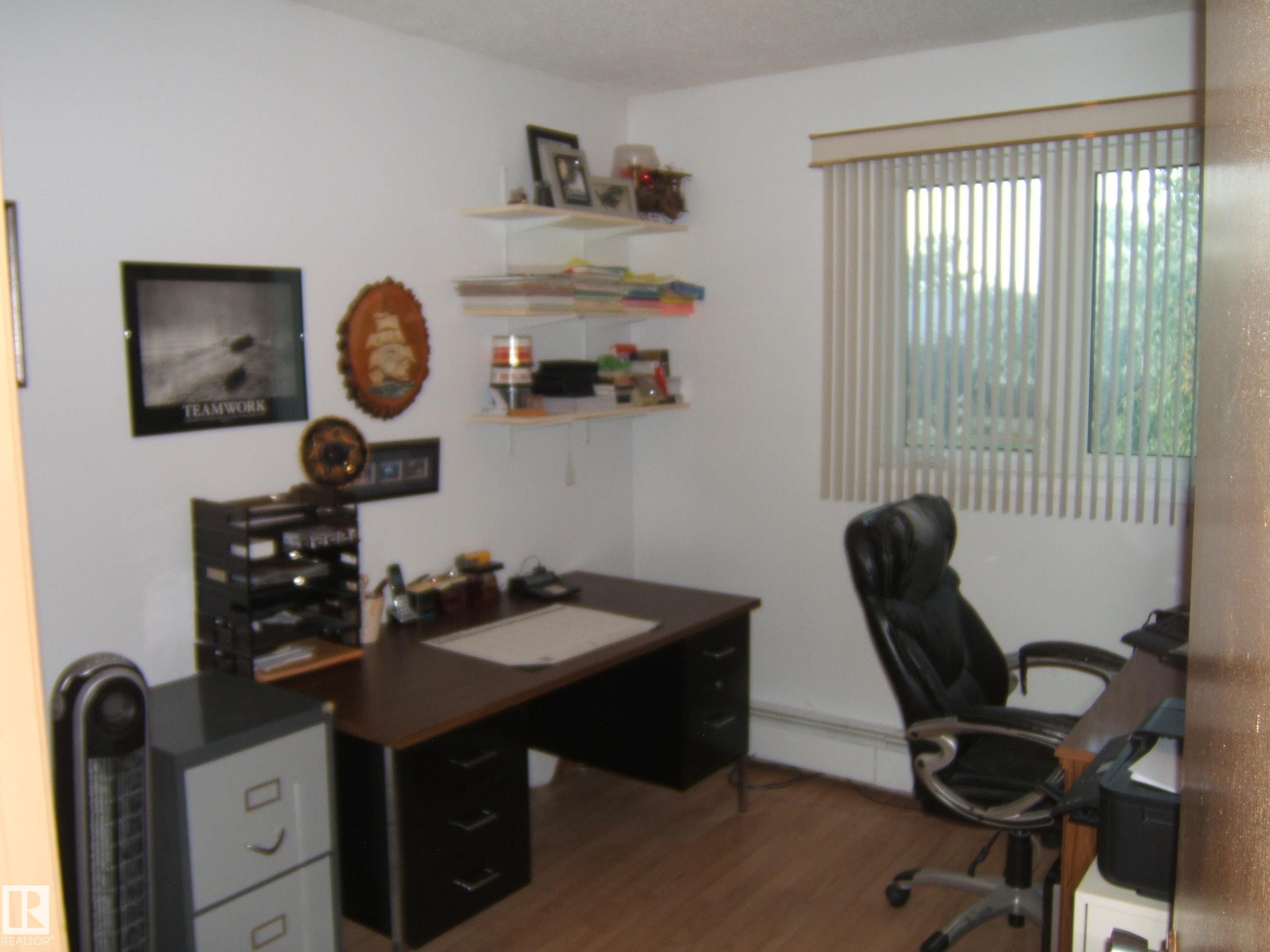 Office space with wood finished floors and a baseboard heating unit - 4807 54 Avenue, Two Hills, AB - Indoor Photo Showing Office