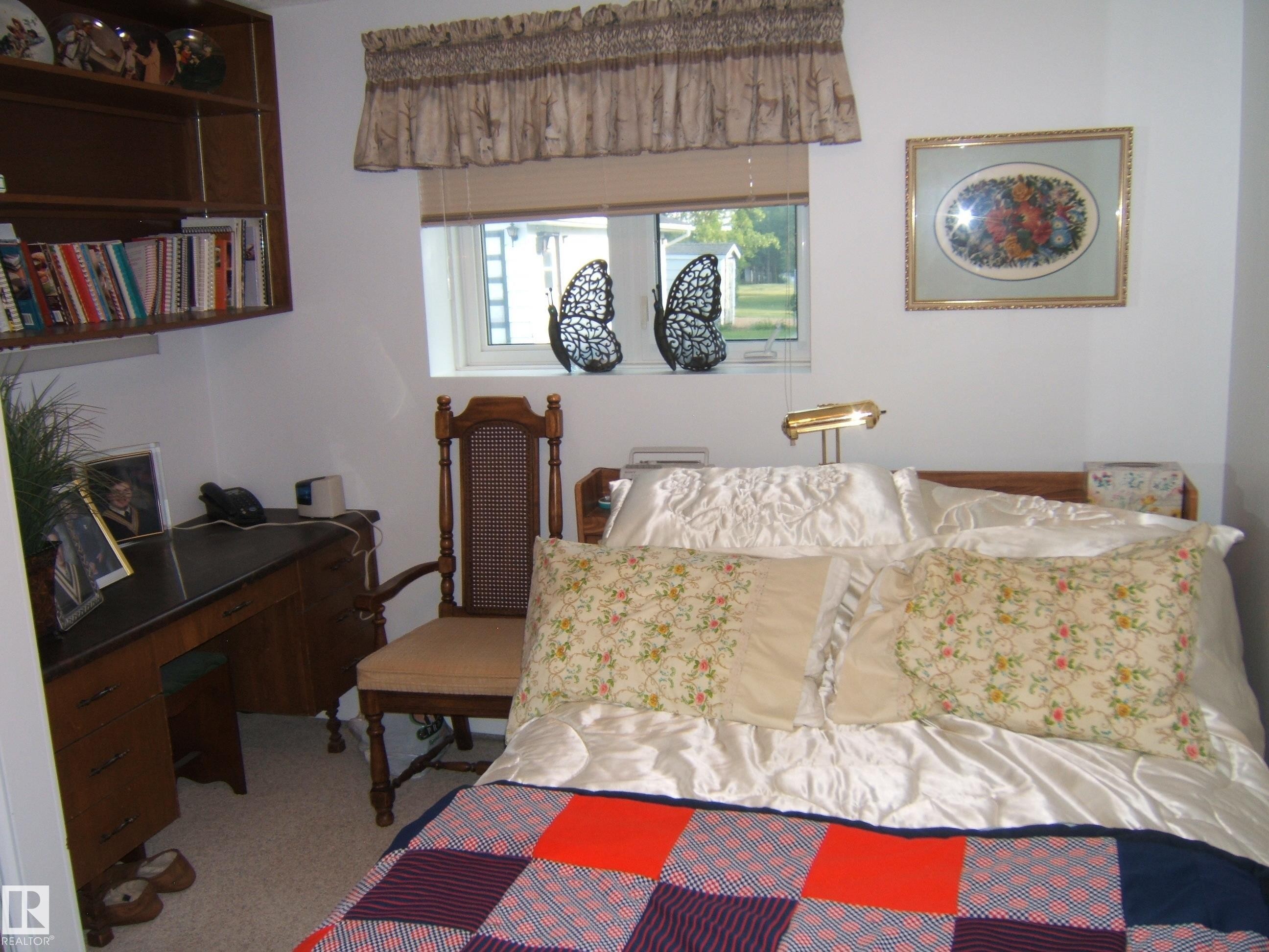 Carpeted bedroom with a desk - 4807 54 Avenue, Two Hills, AB - Indoor Photo Showing Bedroom