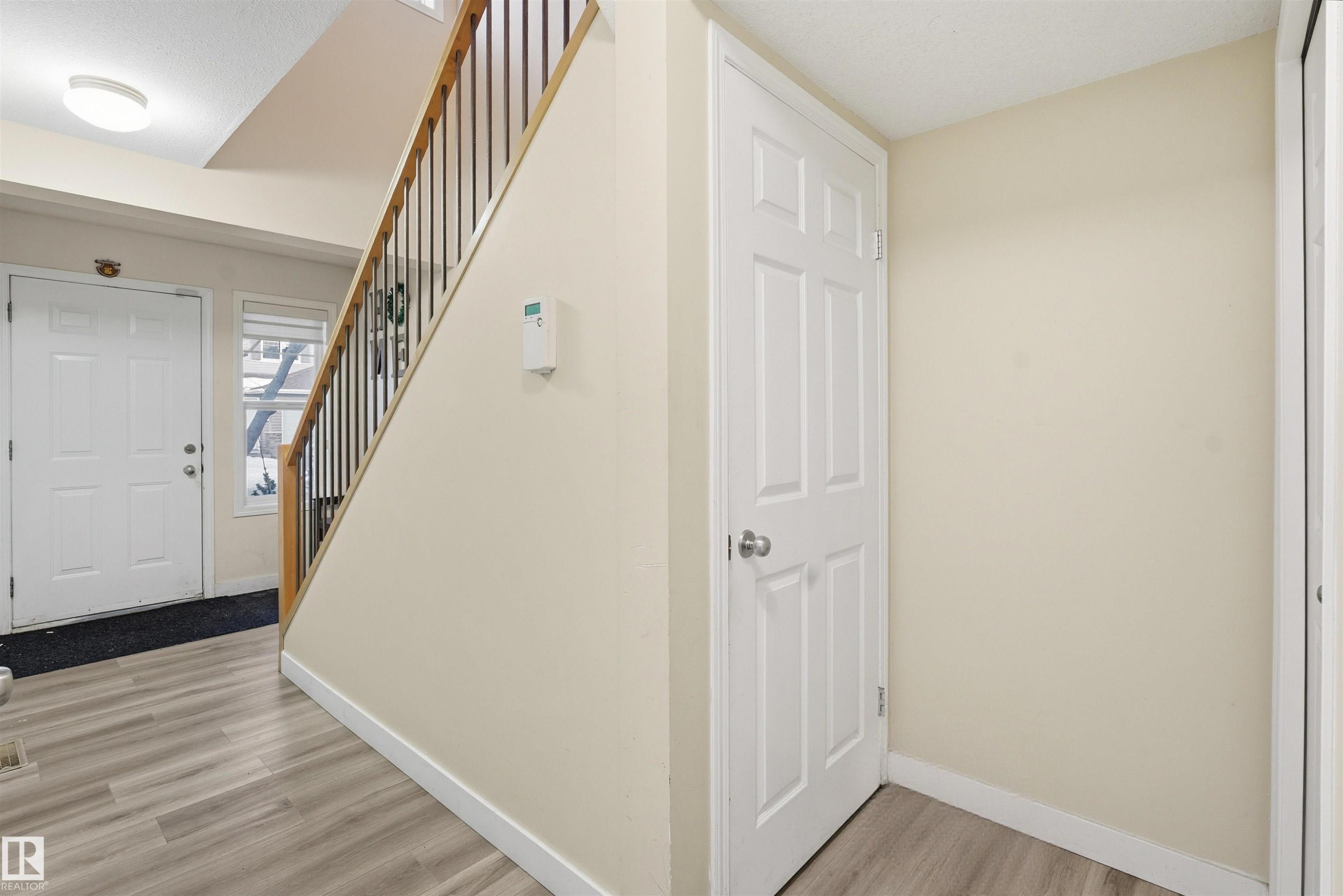 Foyer entrance with light wood-style floors and baseboards - 8 230 Edwards Drive, Edmonton, AB - Indoor Photo Showing Other Room