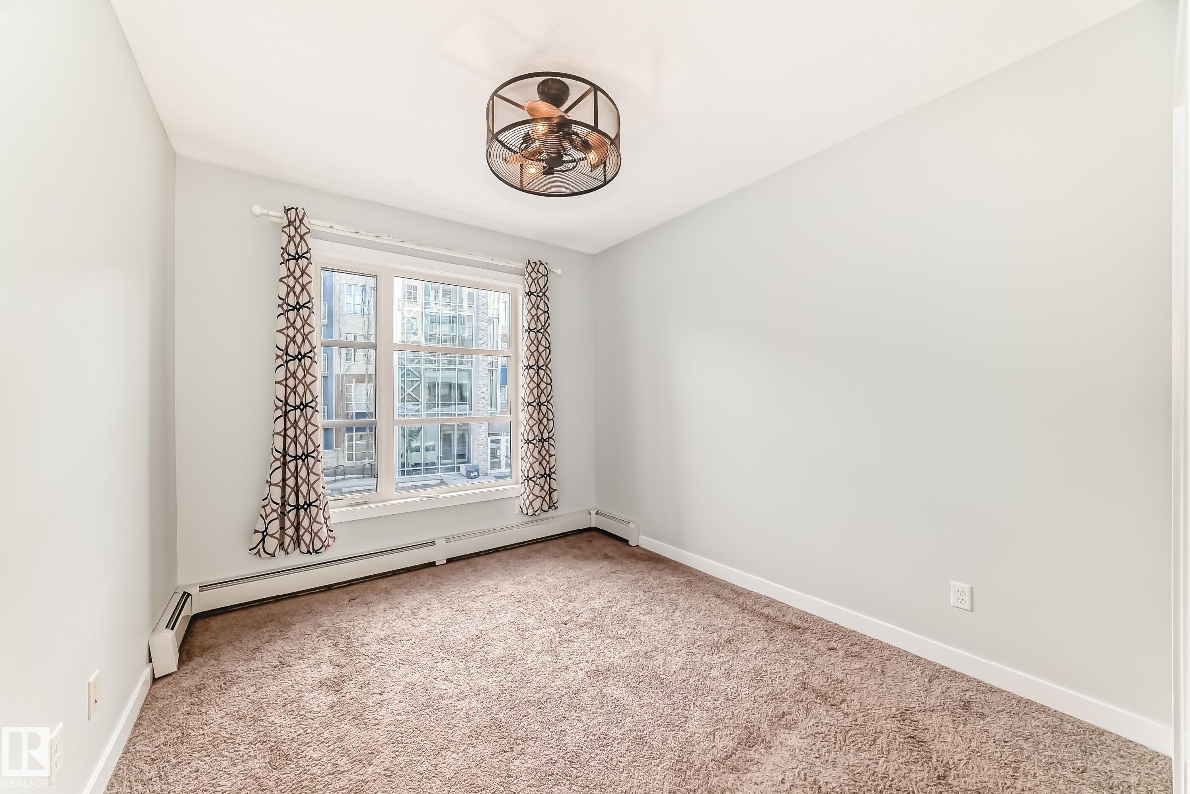 Carpeted empty room featuring baseboard heating - 201 2588 Anderson Way, Edmonton, AB - Indoor Photo Showing Other Room