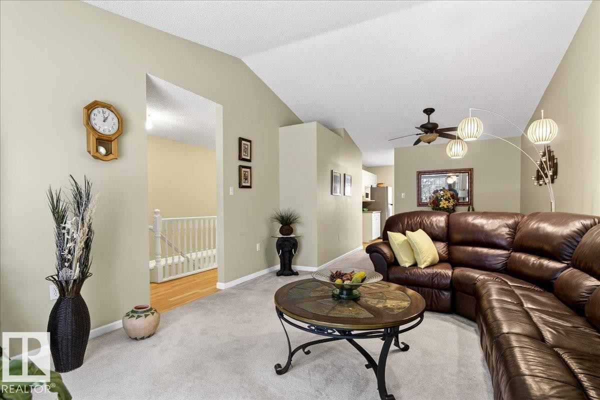Carpeted living room featuring baseboards and ceiling fan - 13217 155 Avenue Nw, Edmonton, AB - Indoor Photo Showing Living Room