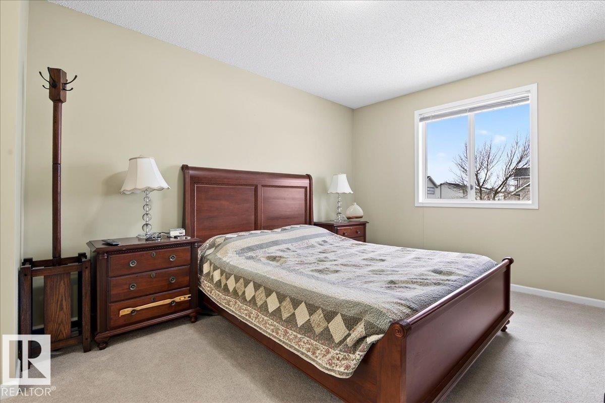 Bedroom featuring light carpet and a textured ceiling - 13217 155 Avenue Nw, Edmonton, AB - Indoor Photo Showing Bedroom
