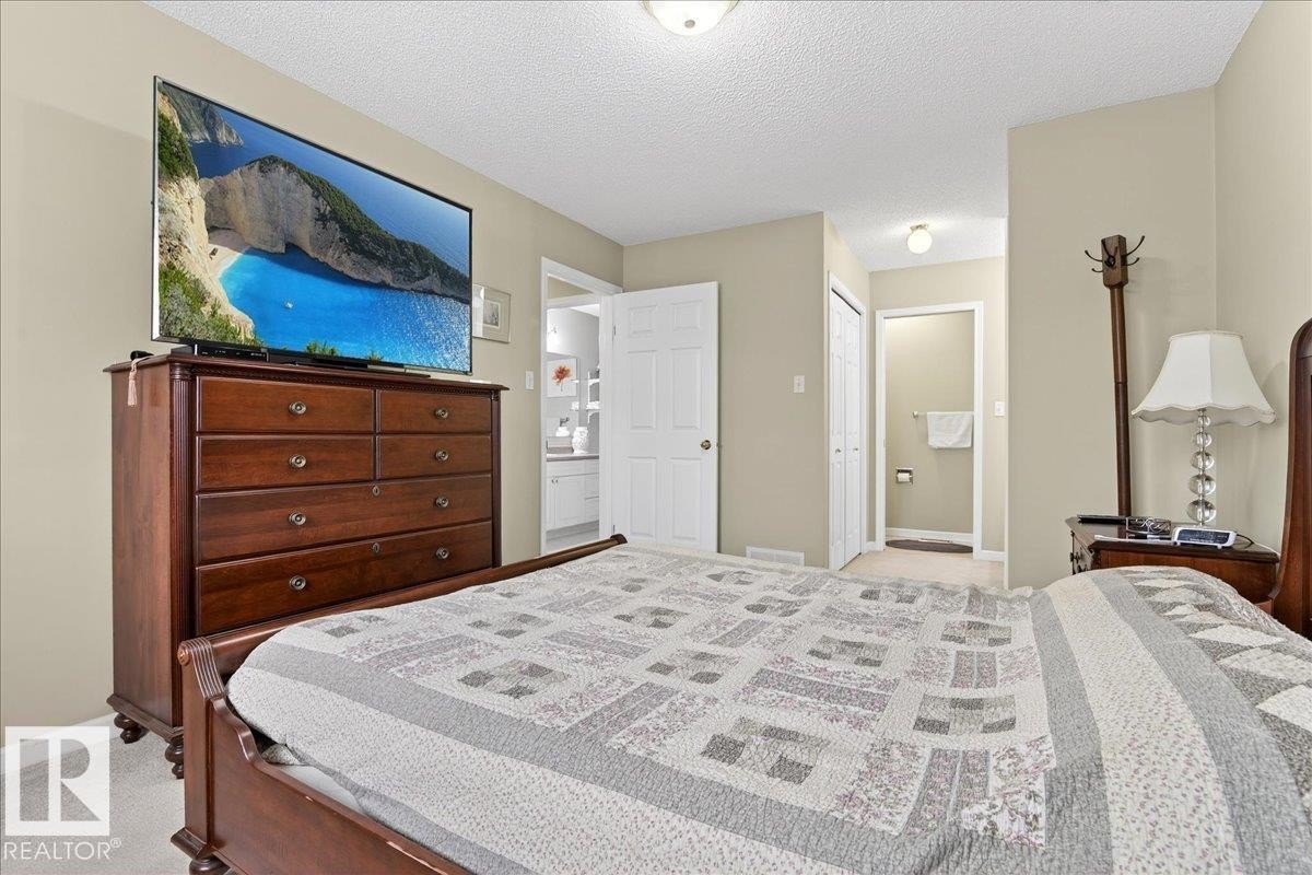 Bedroom featuring light colored carpet, a textured ceiling, and a closet - 13217 155 Avenue Nw, Edmonton, AB - Indoor Photo Showing Bedroom