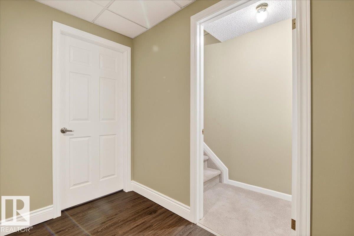 Interior space featuring a paneled ceiling and dark wood finished floors - 13217 155 Avenue Nw, Edmonton, AB - Indoor Photo Showing Other Room