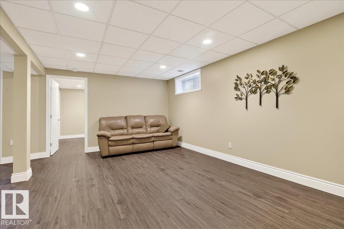 Living area featuring dark wood finished floors, a drop ceiling, and recessed lighting - 13217 155 Avenue Nw, Edmonton, AB - Indoor