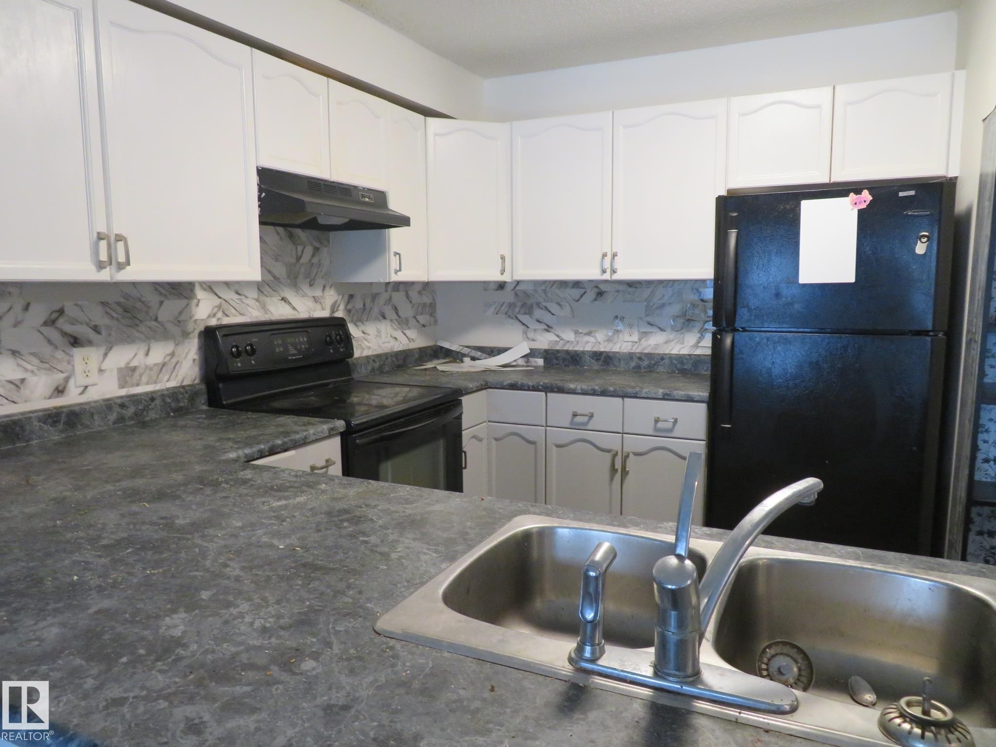 Kitchen with dark countertops, black appliances, white cabinets, and backsplash - 2945 26 Street, Edmonton, AB - Indoor Photo Showing Kitchen With Double Sink