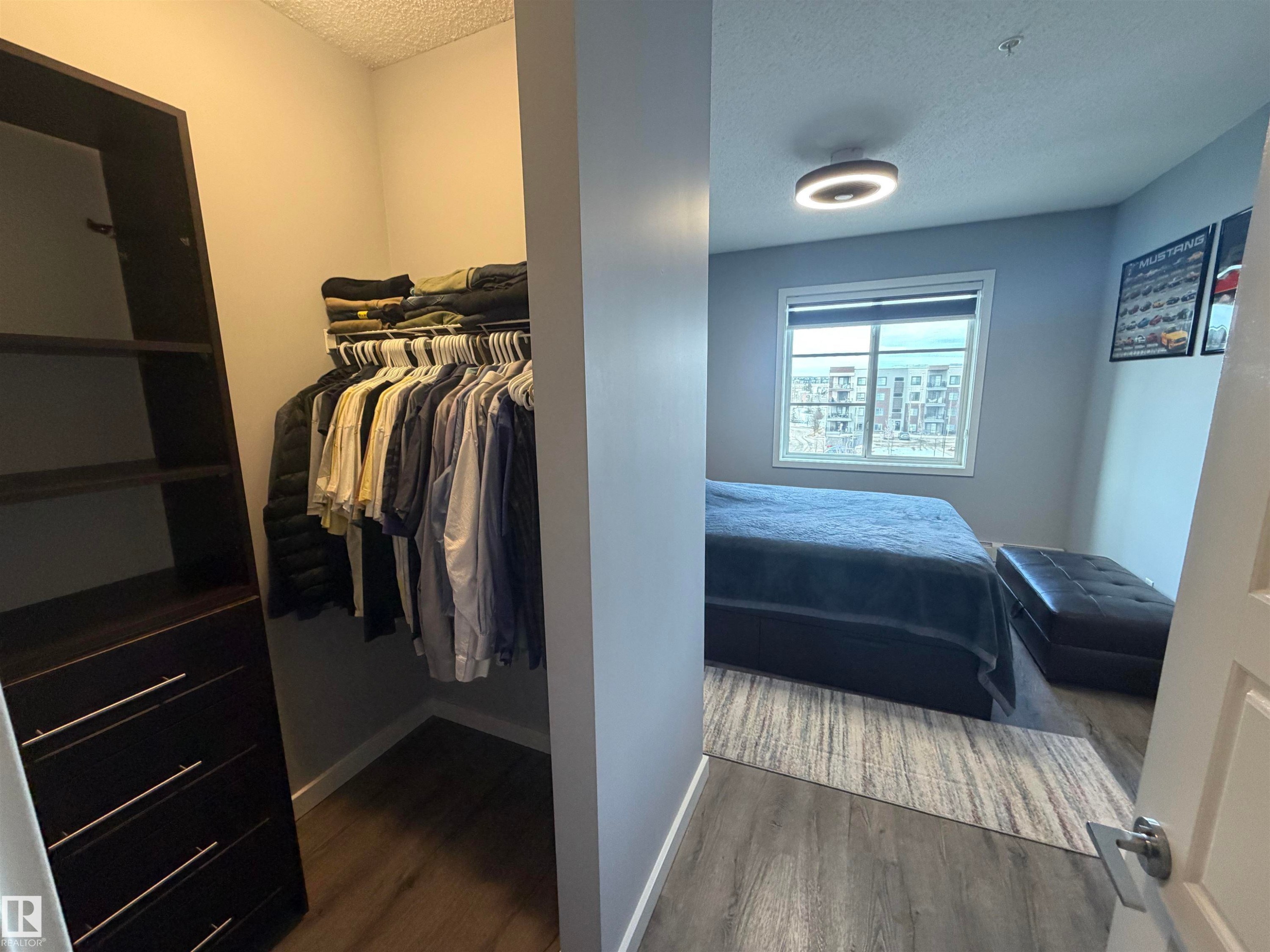 Bedroom featuring a textured ceiling and dark wood-type flooring - 417 1004 Rosenthal Boulevard, Edmonton, AB - Indoor