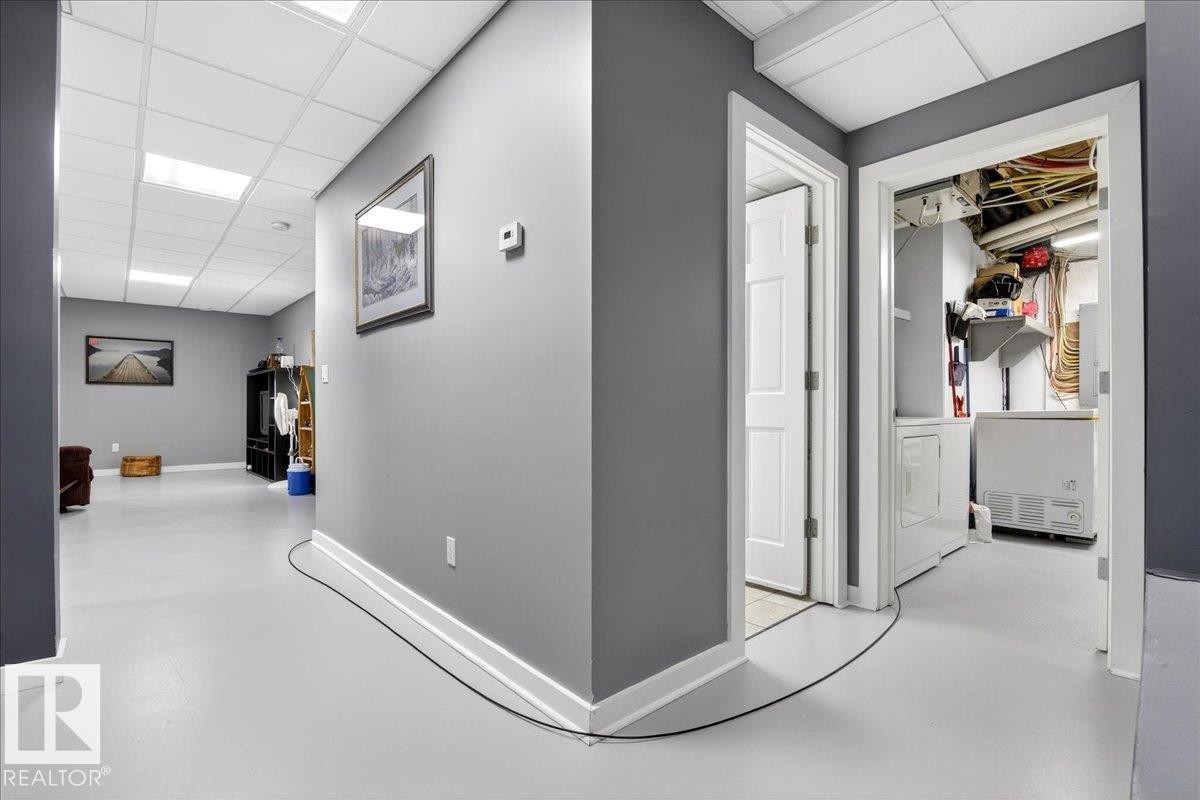 Hall featuring concrete floors, a drop ceiling, and washer / clothes dryer - 5019 48 Avenue, Chipman, AB - Indoor Photo Showing Other Room