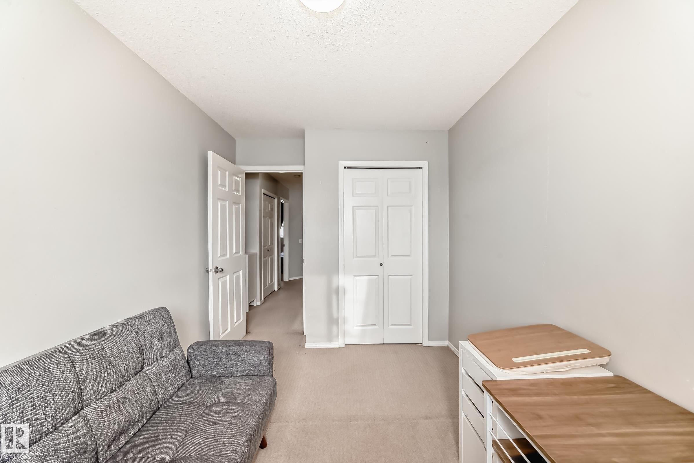 Living area with light colored carpet and baseboards - 185 230 Edwards Drive, Edmonton, AB