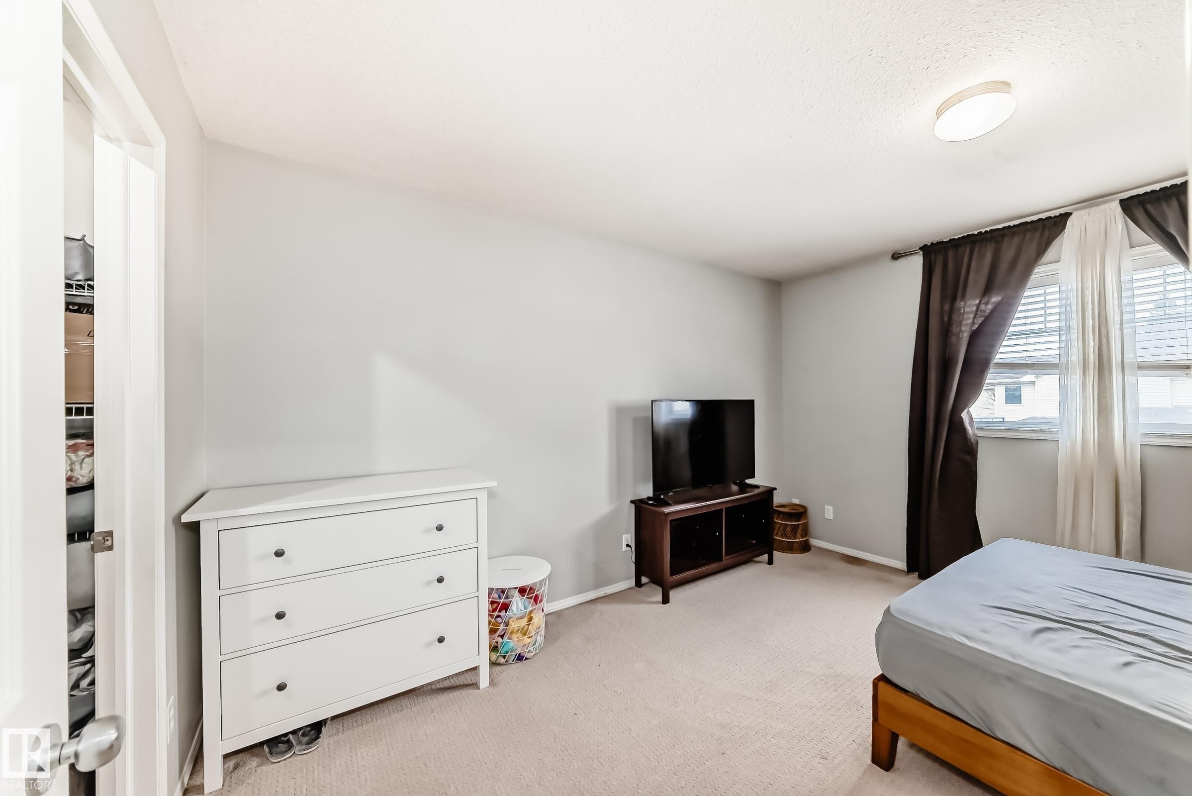 Bedroom with light colored carpet and baseboards - 185 230 Edwards Drive, Edmonton, AB