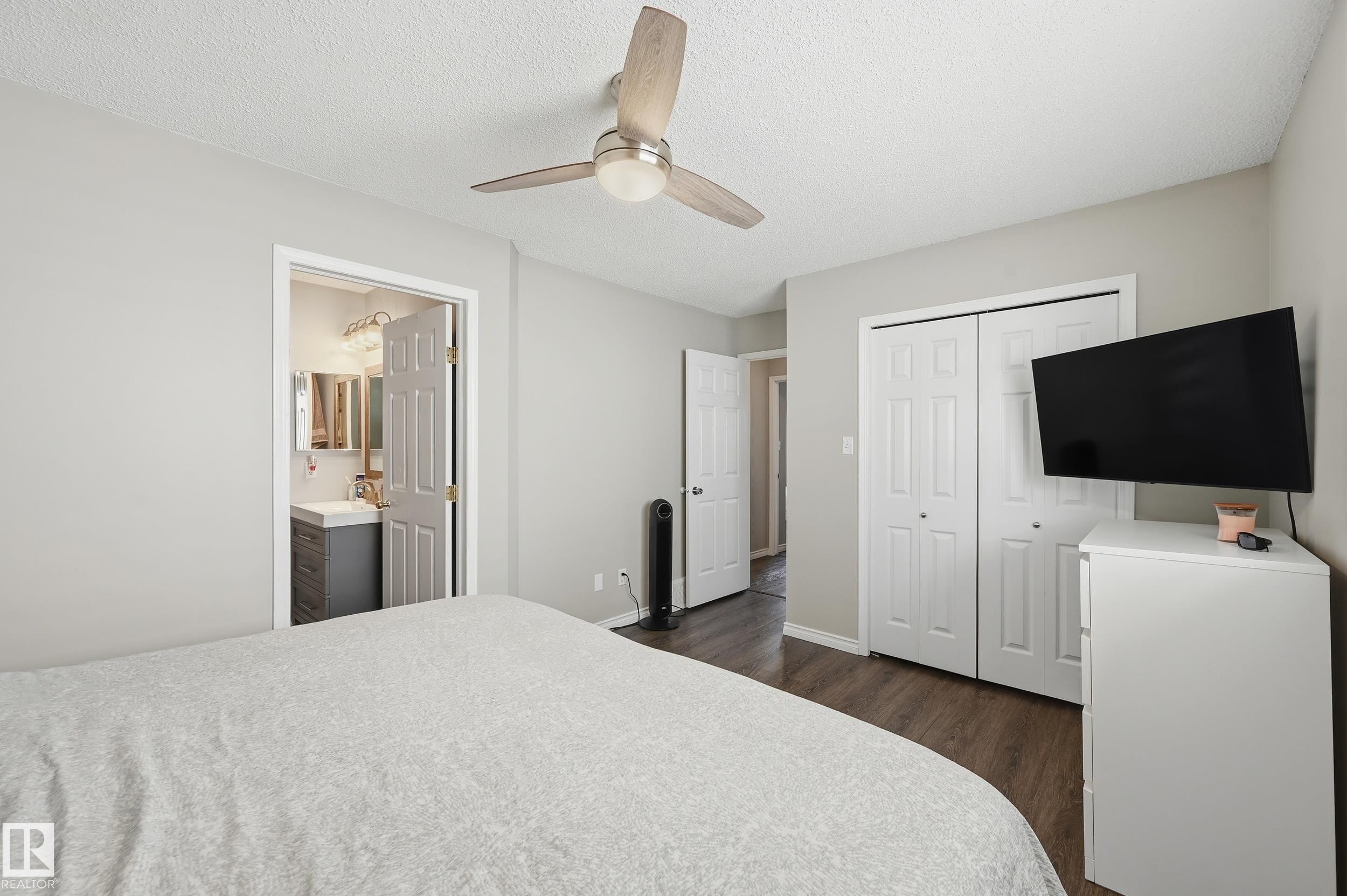 Bedroom with a closet, ceiling fan, dark wood-type flooring, a textured ceiling, and ensuite bathroom - 2952 39 Avenue, Edmonton, AB - Indoor Photo Showing Bedroom