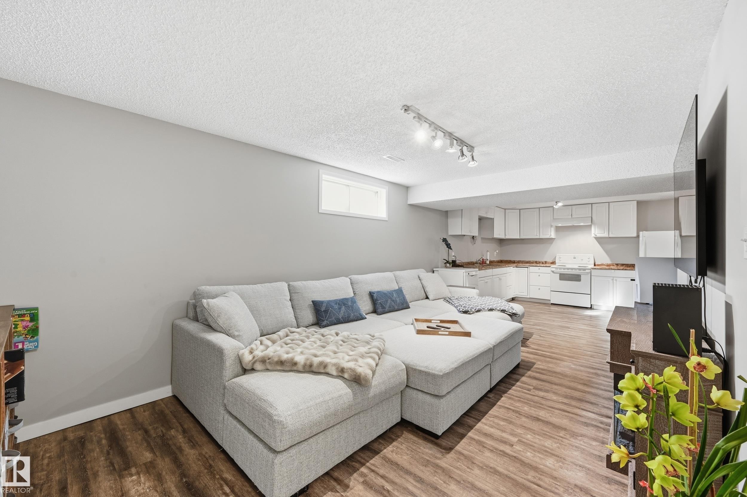 Living room with light wood-style flooring, a textured ceiling, and track lighting - 2952 39 Avenue, Edmonton, AB - Indoor Photo Showing Living Room