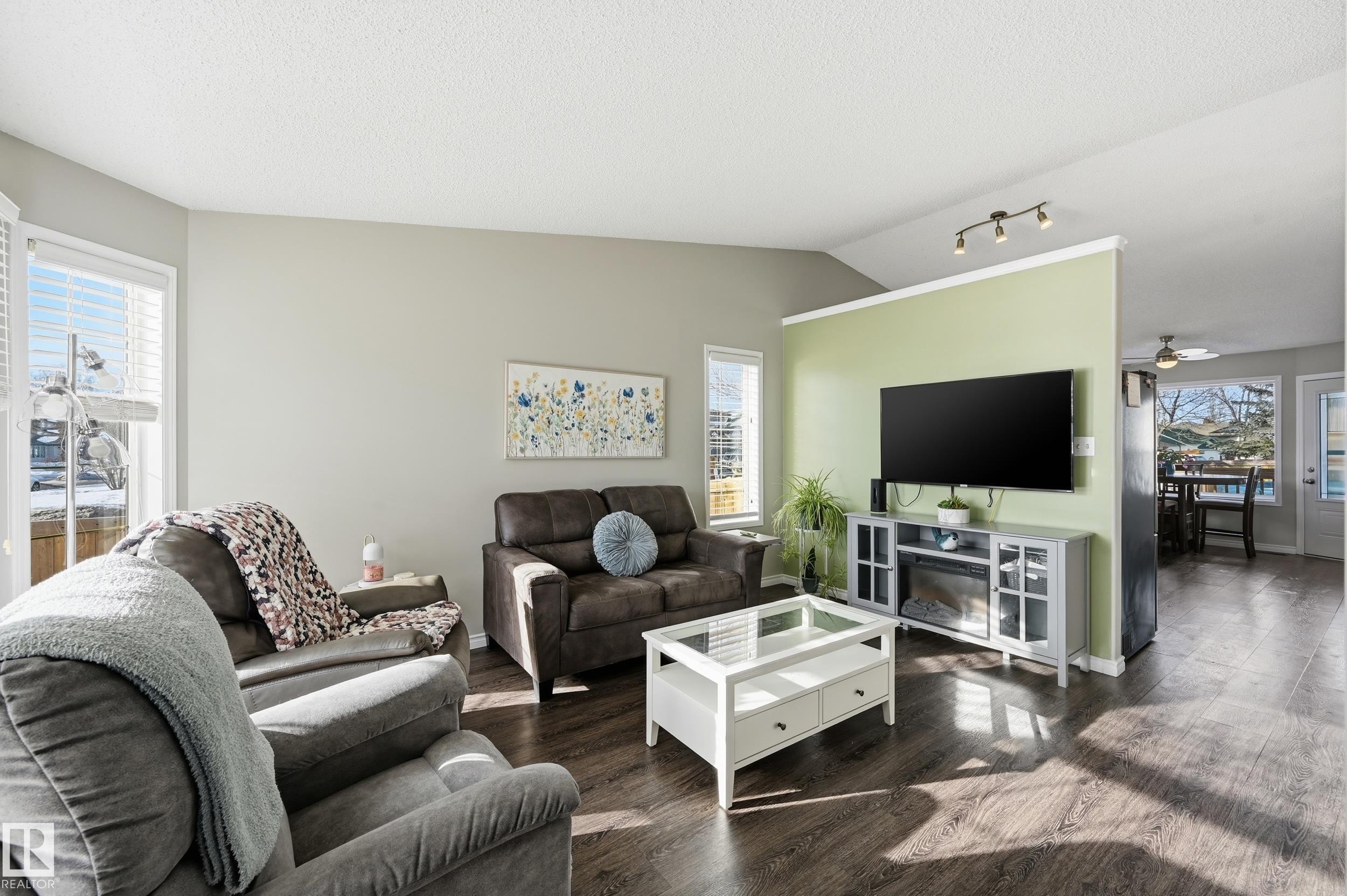 Living room featuring wood finished floors, plenty of natural light, a ceiling fan, and track lighting - 2952 39 Avenue, Edmonton, AB - Indoor Photo Showing Living Room
