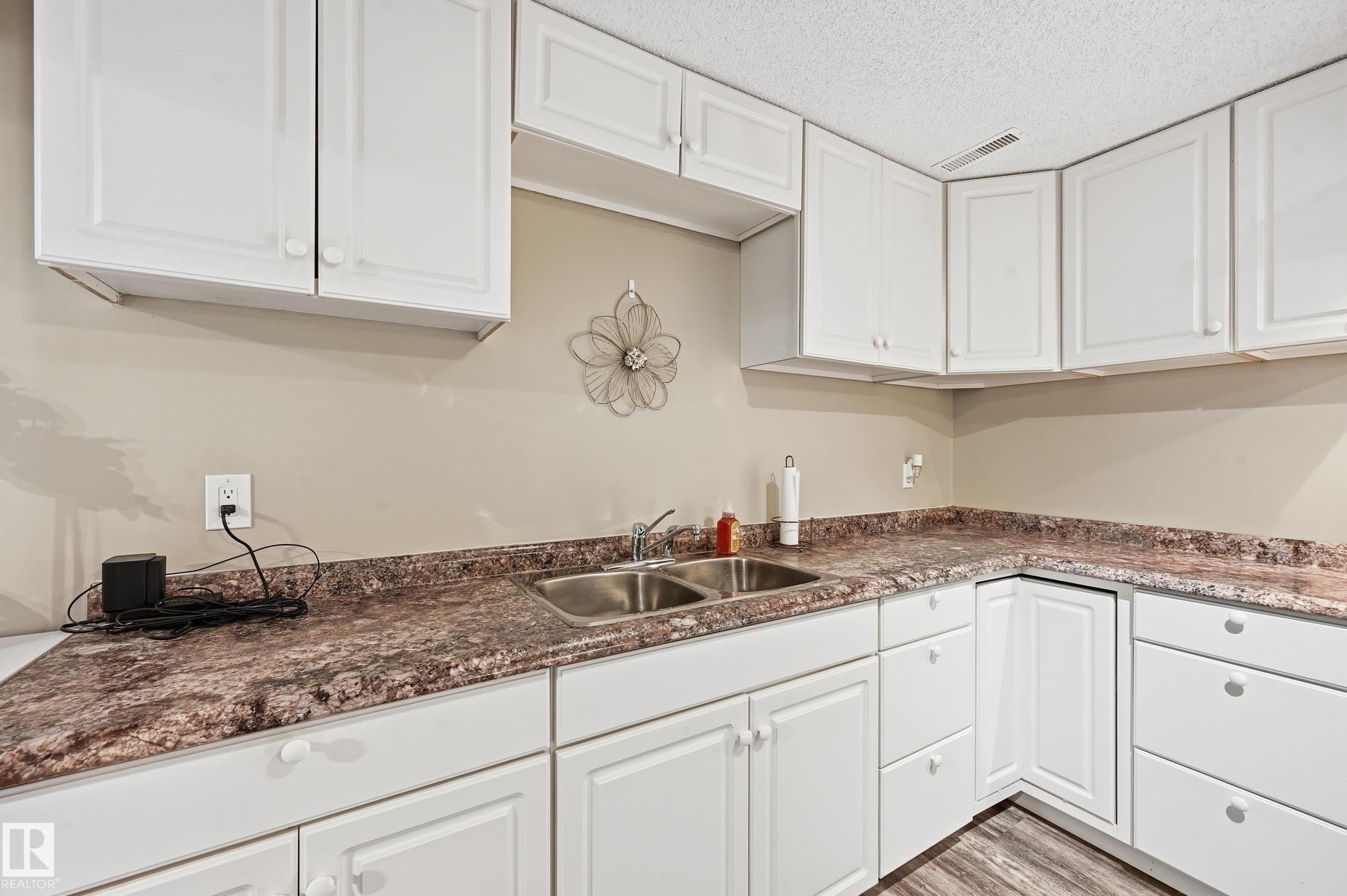 Kitchen with white cabinetry, dark countertops, and a textured ceiling - 2952 39 Avenue, Edmonton, AB - Indoor Photo Showing Kitchen With Double Sink