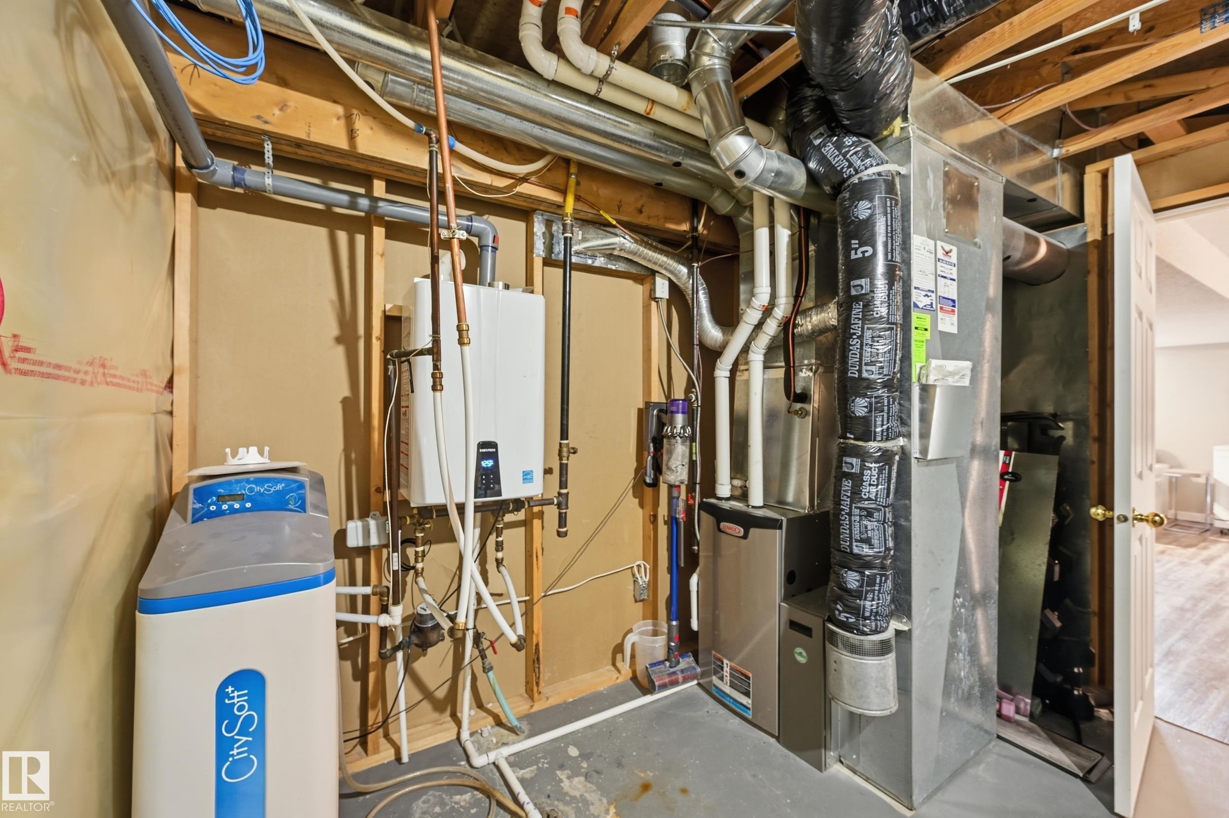 Utility room featuring heating unit and tankless water heater - 2952 39 Avenue, Edmonton, AB - Indoor Photo Showing Basement