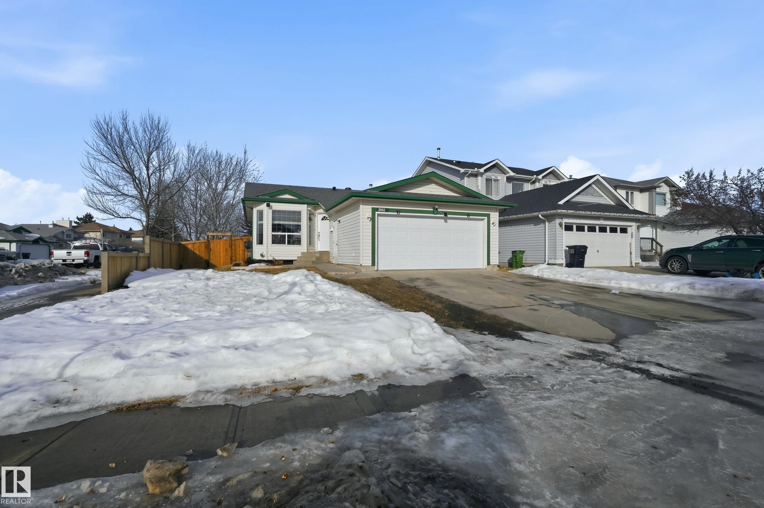 View of front of property featuring concrete driveway, an attached garage, and a residential view - 2952 39 Avenue, Edmonton, AB - Outdoor