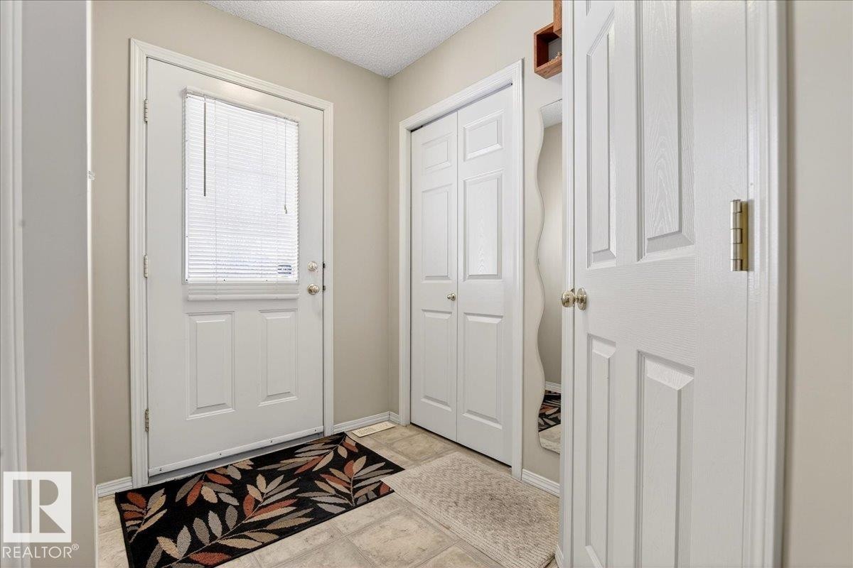 Doorway featuring a textured ceiling and baseboards - 23 4020 21 Street, Edmonton, AB - Indoor Photo Showing Other Room