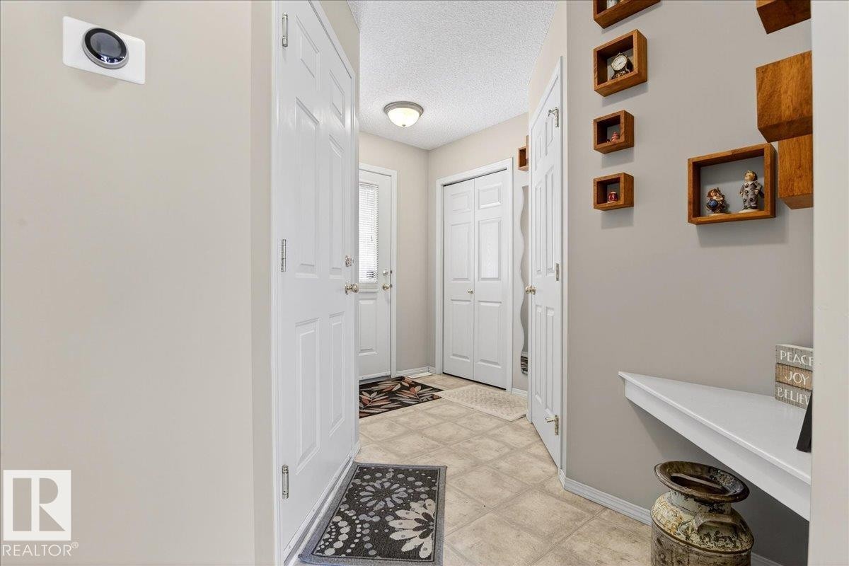 Doorway with a textured ceiling and baseboards - 23 4020 21 Street, Edmonton, AB - Indoor Photo Showing Other Room