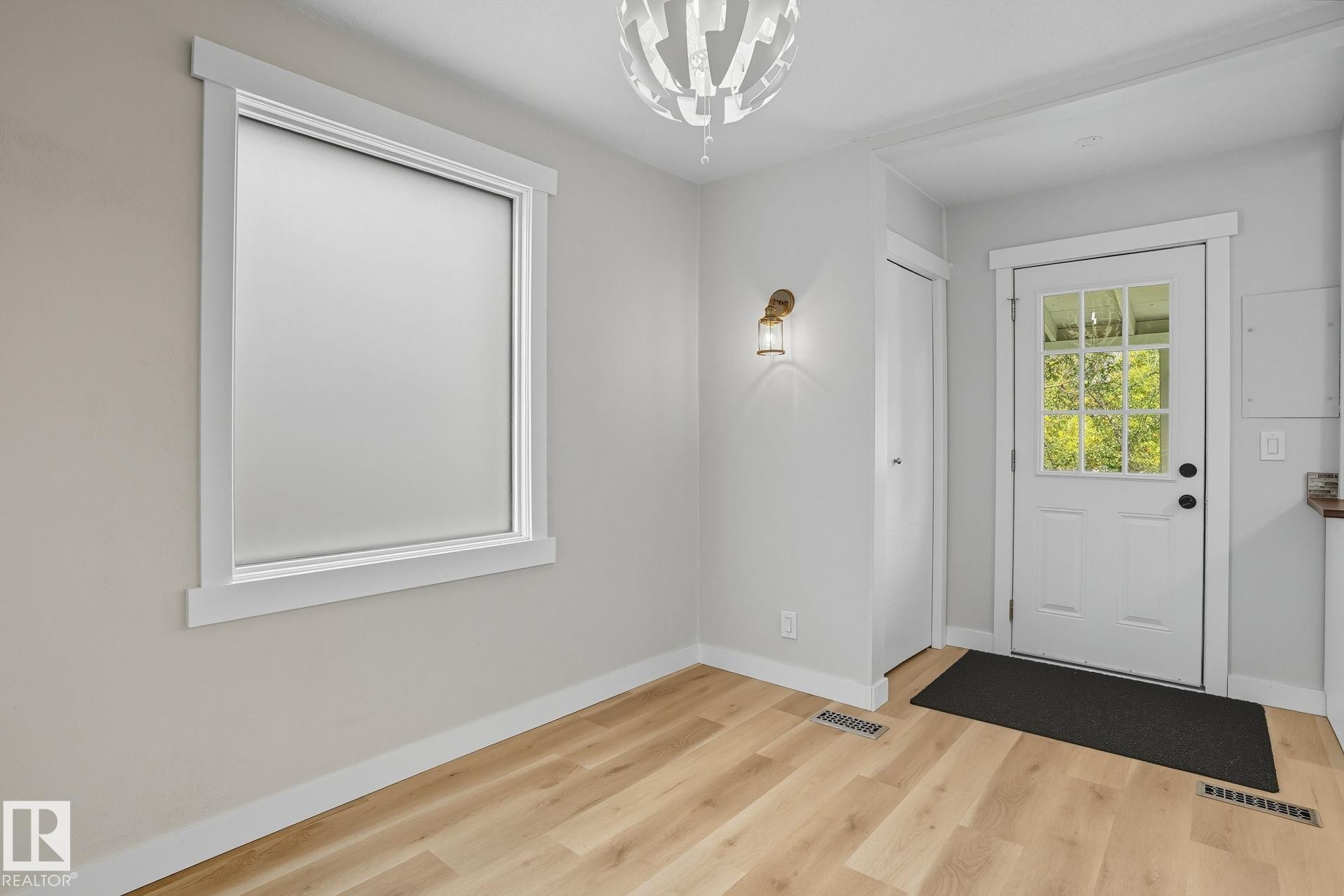 Entrance foyer featuring light wood-style floors and a chandelier - 11222 71 Avenue, Edmonton, AB - Indoor Photo Showing Other Room
