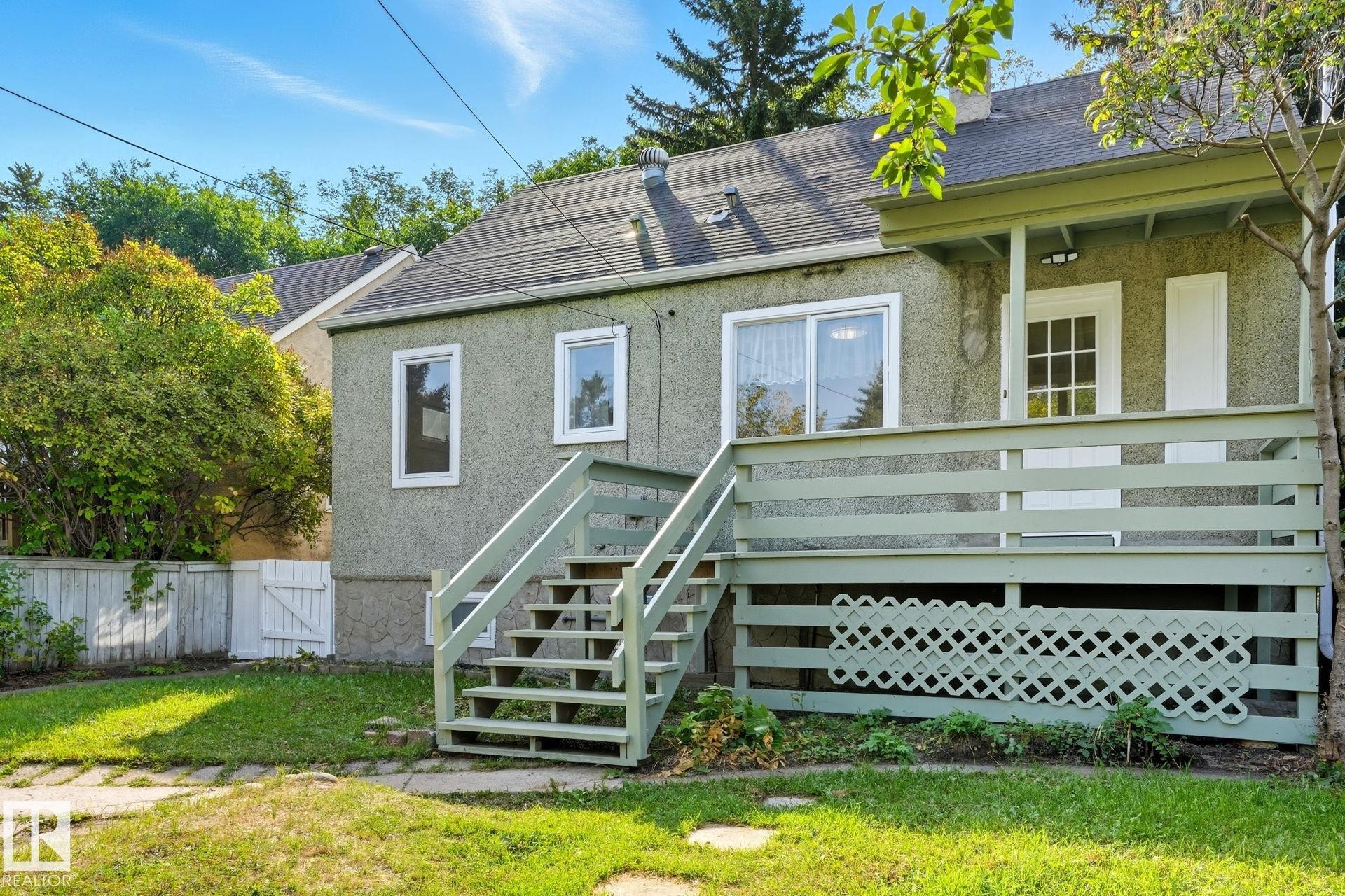 Back of property with stucco siding, stairs, a gate, and roof with shingles - 11222 71 Avenue, Edmonton, AB - Outdoor